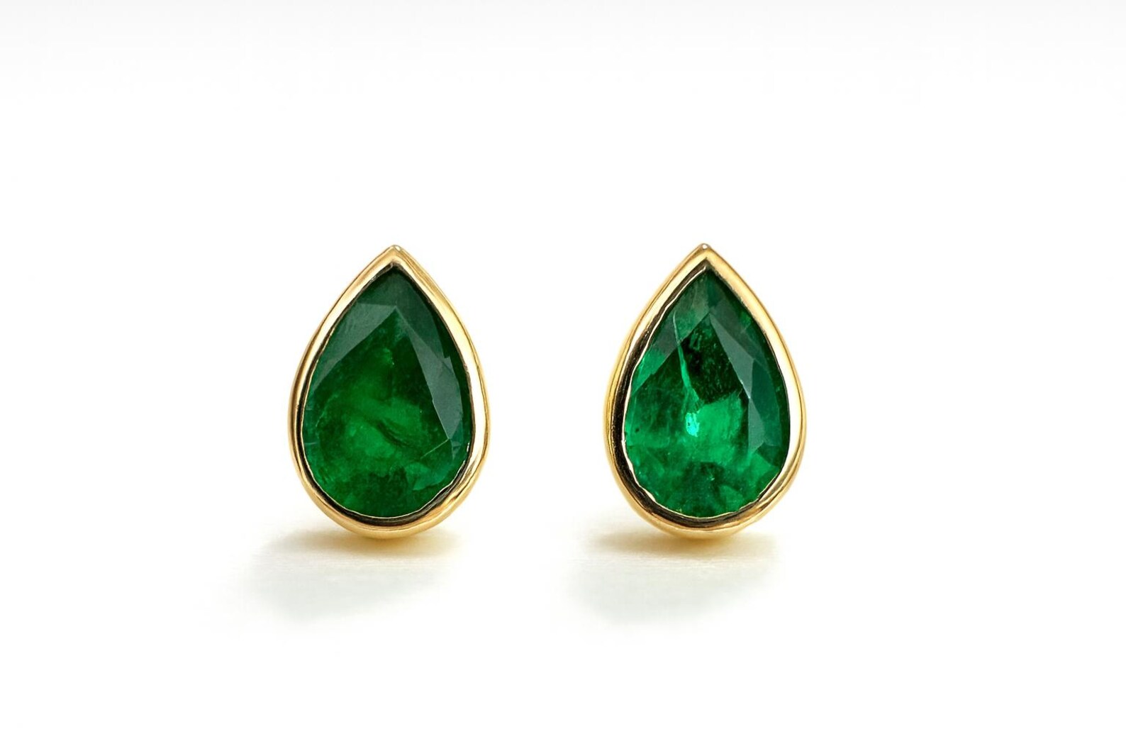 Rich green pear cut Zambian emerald stud earrings with bezel setting, featuring 0.68 carats from JR Colombian Emeralds.