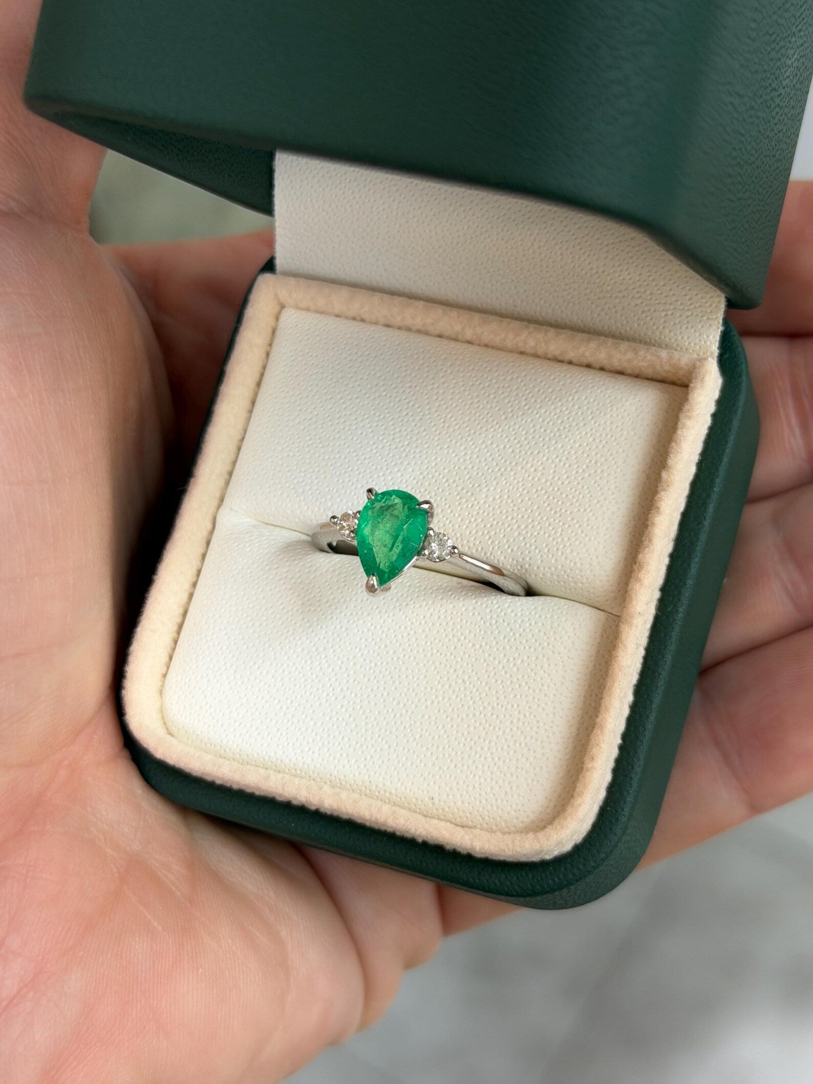 Pear-shaped Colombian emerald engagement ring with three stones set in platinum prongs by JR Colombian Emeralds.