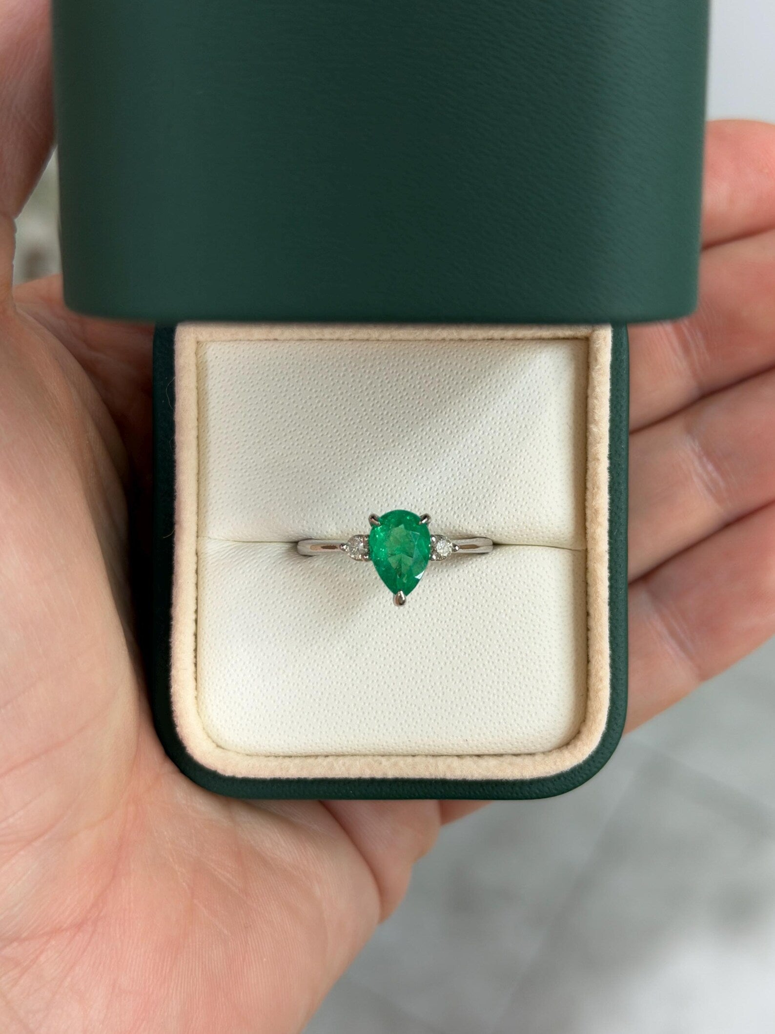 Pear cut Colombian emerald three stone engagement ring with platinum prong setting from JR Colombian Emeralds.