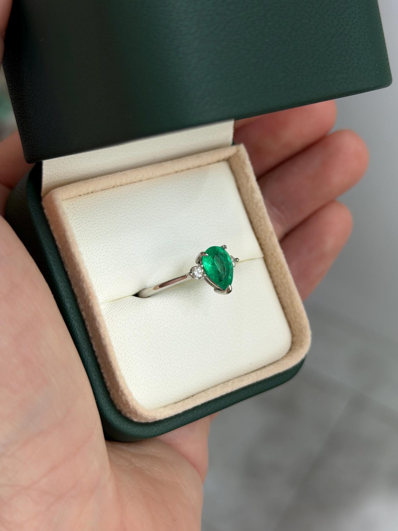 Pear-shaped Colombian emerald three-stone engagement ring with platinum prong setting from JR Colombian Emeralds.