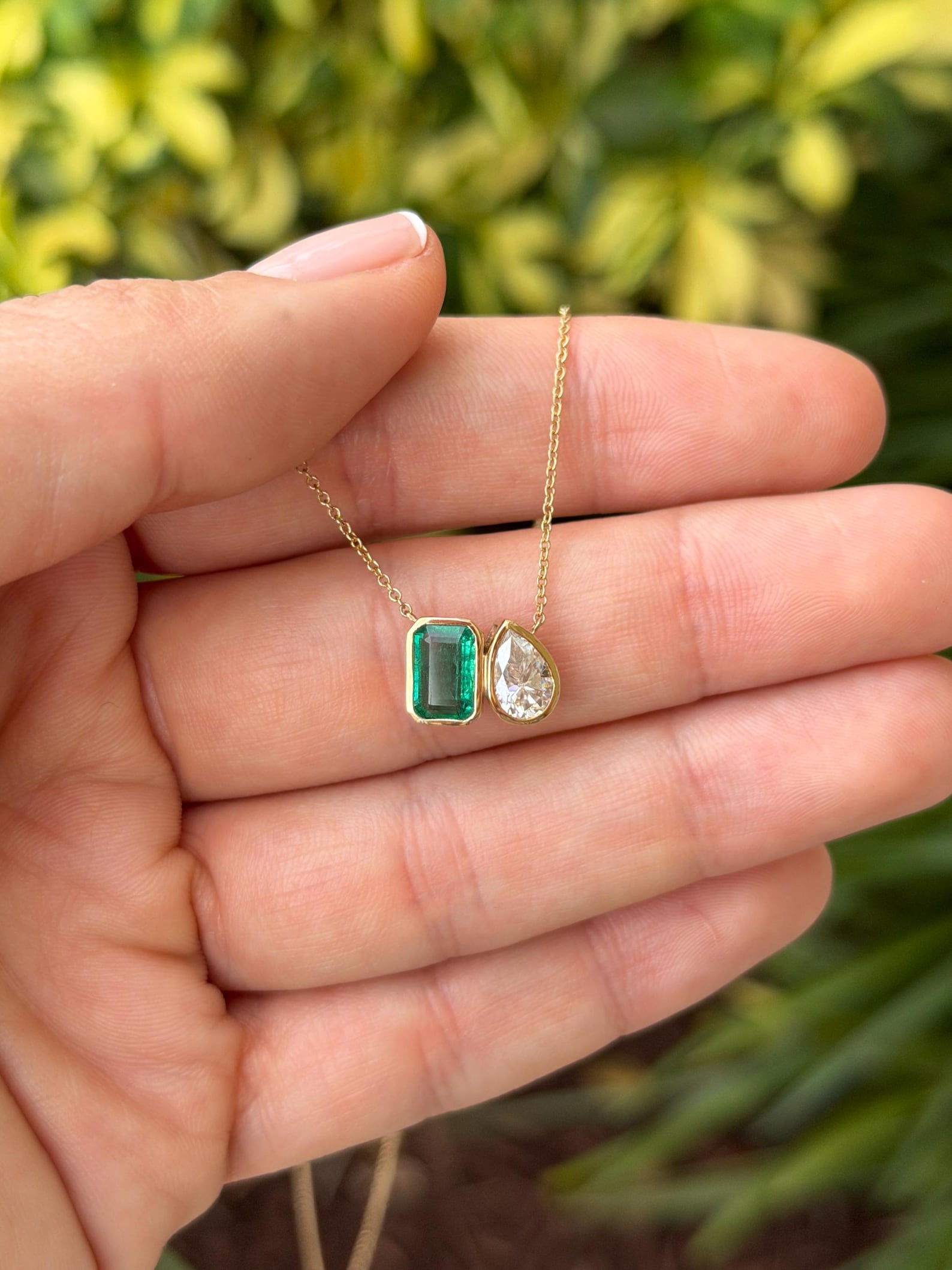 Emerald moissanite toi et moi pendant necklace with two sparkling stones on a chain, by JR Colombian Emeralds.