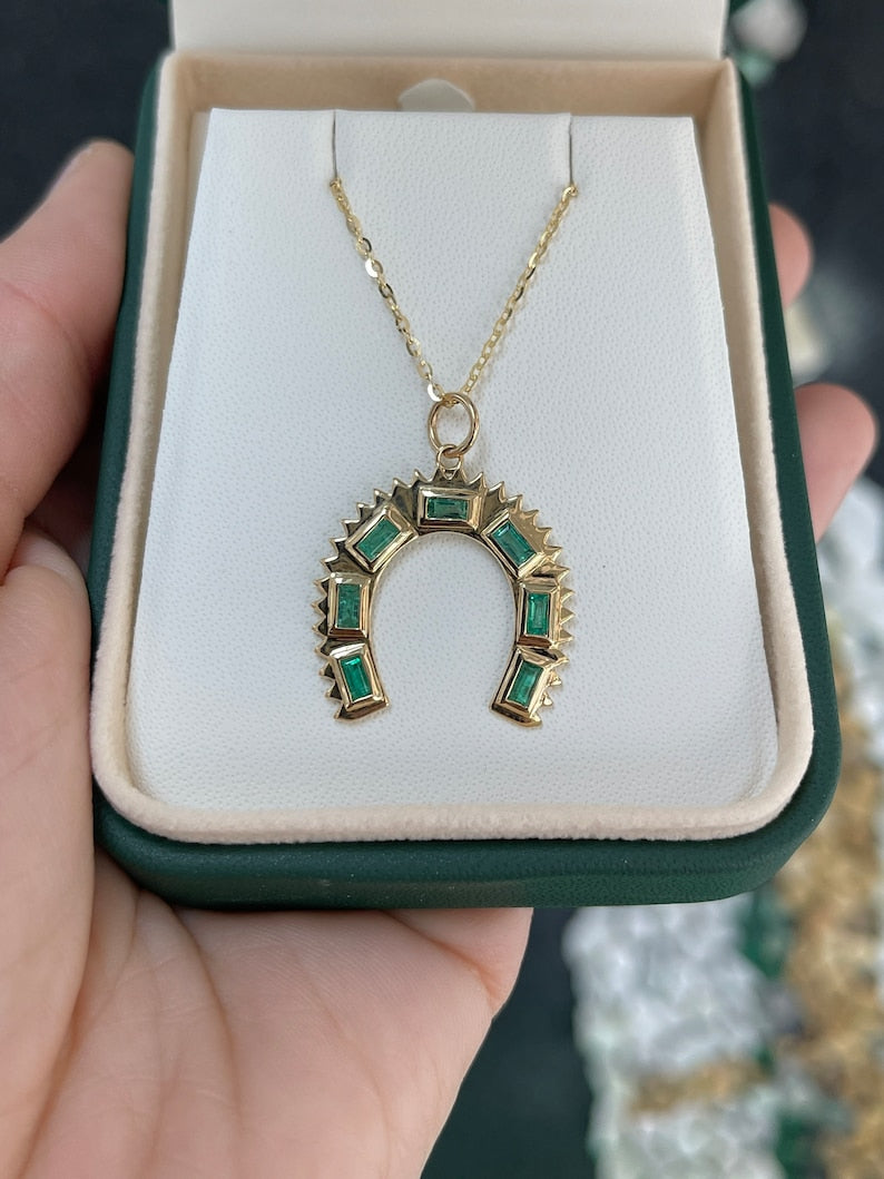 Natural Earth Mined Baguette Emeralds enhance the 14K Gold Horse Shoe Pendant Necklace with a Total Carat Weight of 0.90