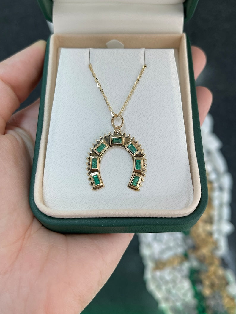 14K Gold Pendant Necklace adorned with Baguette Emeralds totaling 0.90 Carats and a Horse Shoe Design