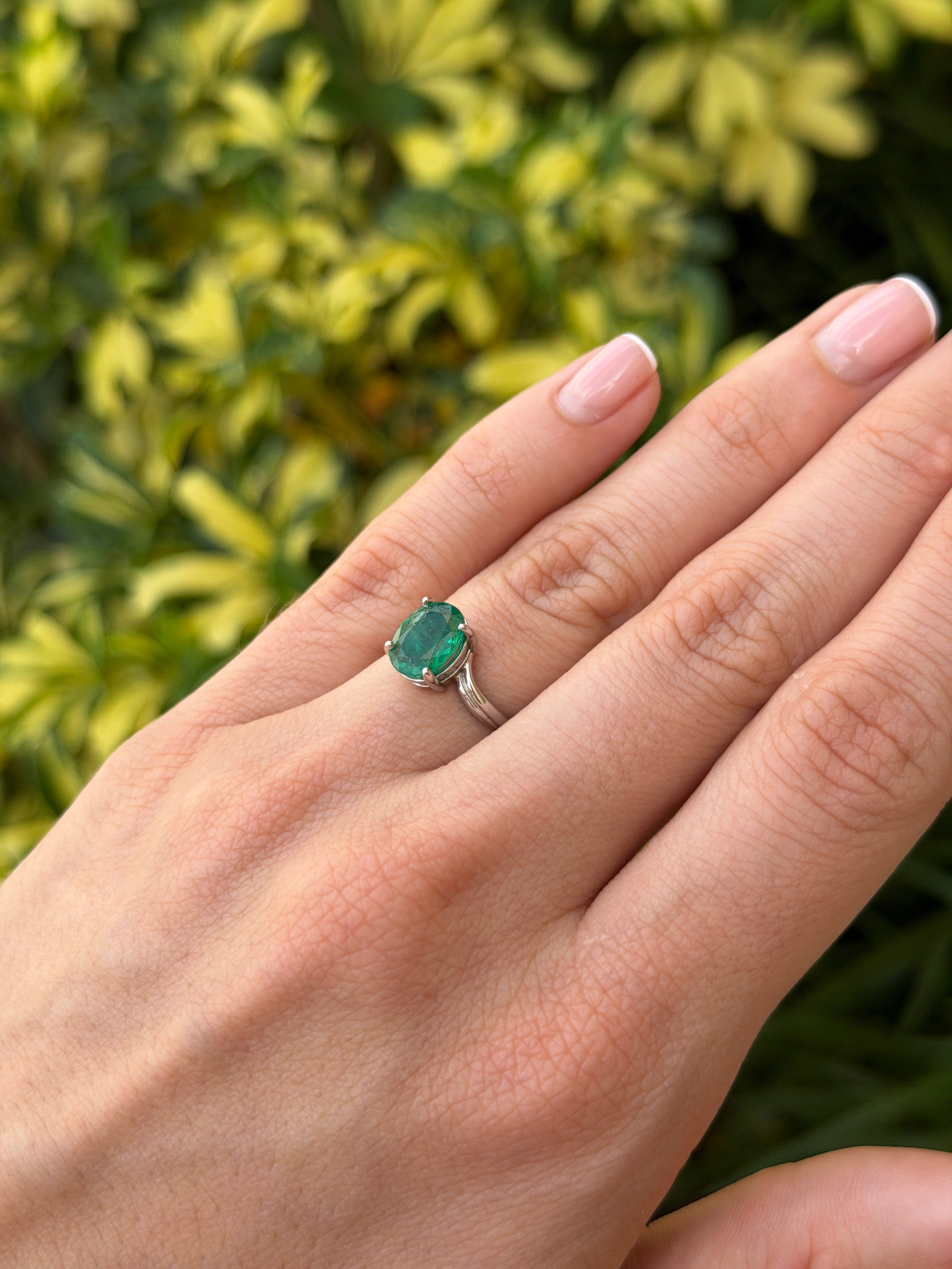 Natural 2.05ct oval emerald solitaire wave ring in 14K white gold from JR Colombian Emeralds, showing the elegant gemstone and band.
