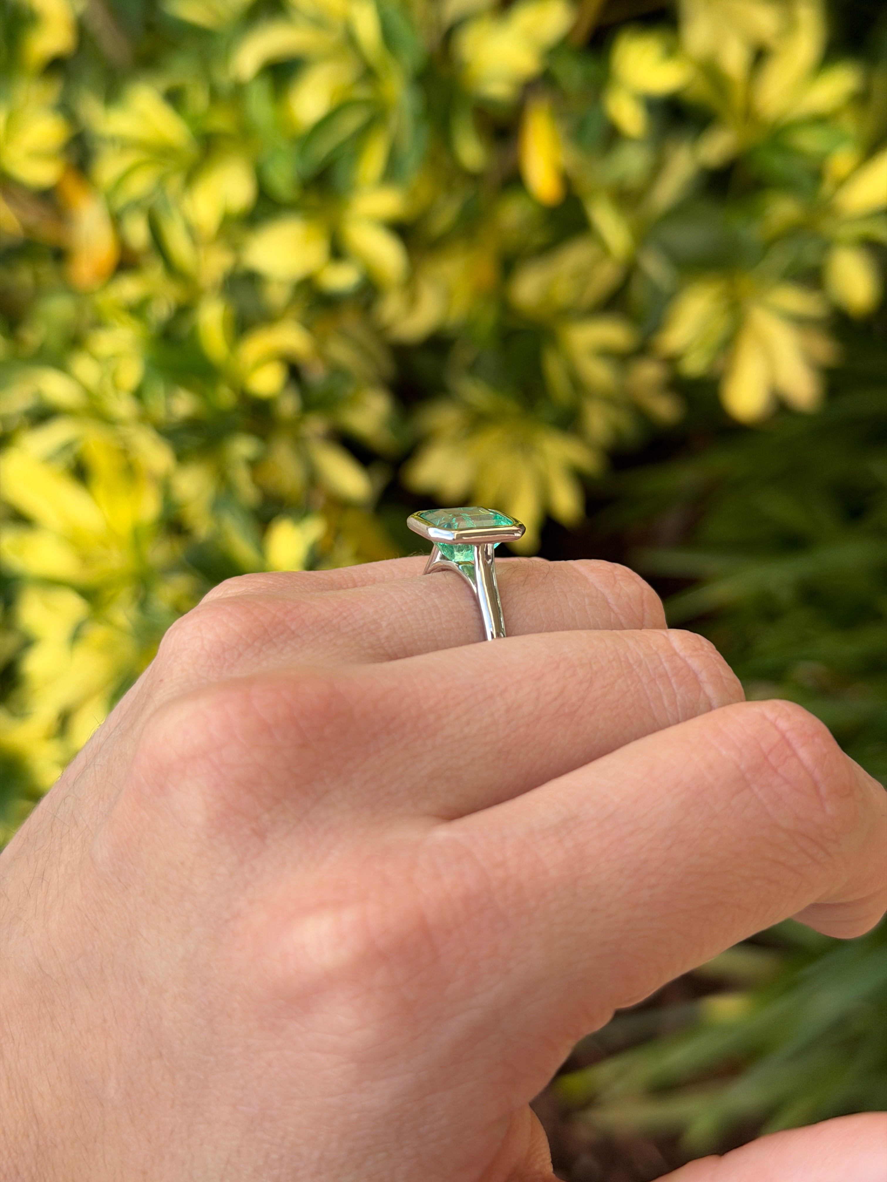 18K white gold ring featuring a 3.46ct bezel-set Colombian emerald solitaire with vibrant green color