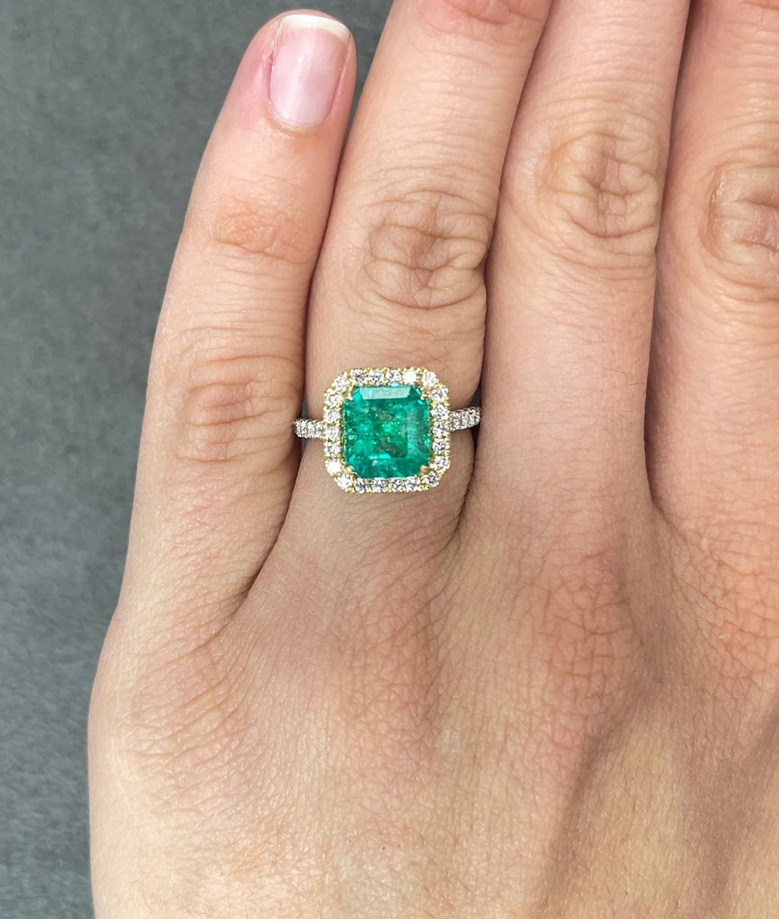 Asscher cut Colombian emerald and diamond halo ring in two-tone 18K gold by JR Colombian Emeralds.