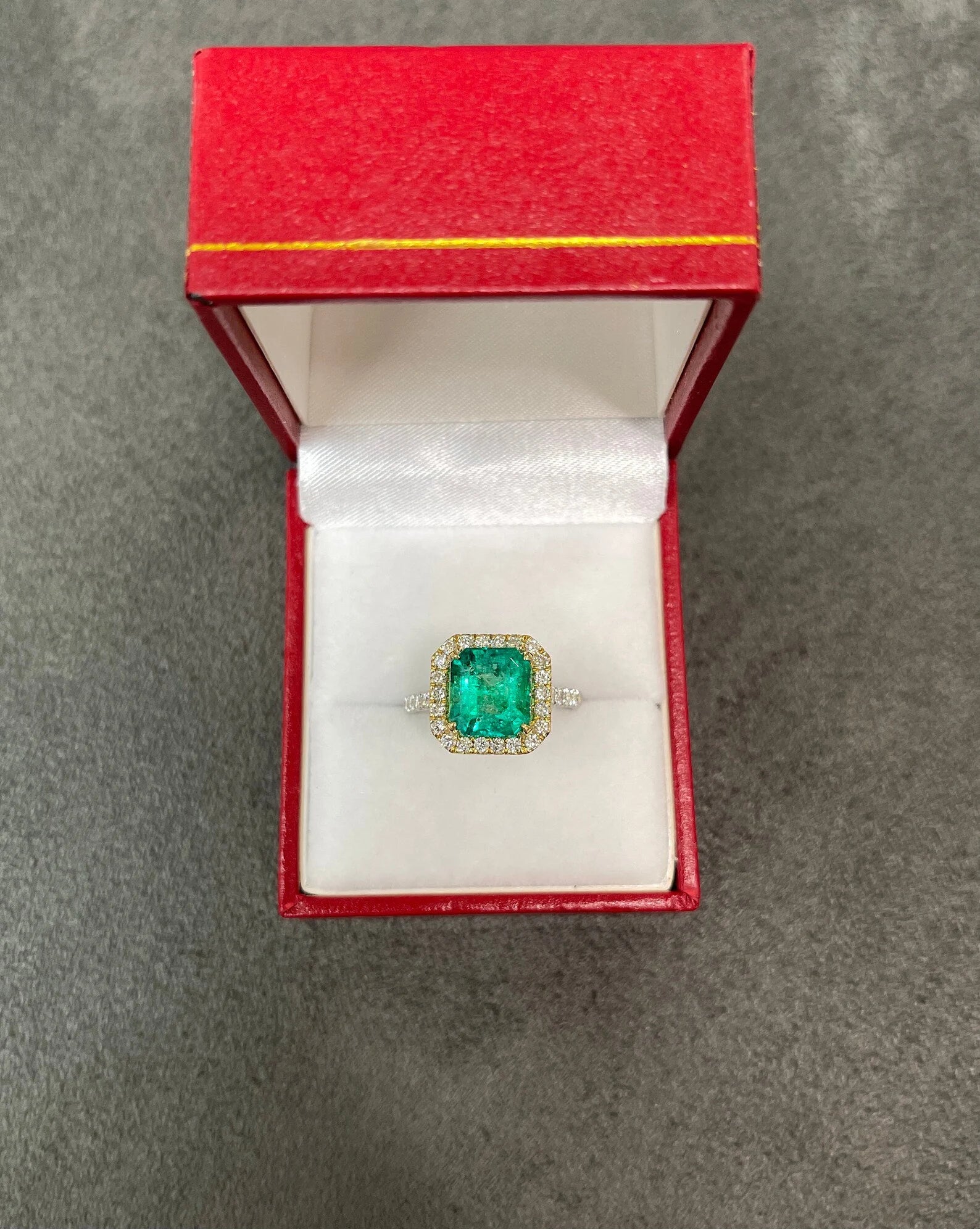 Asscher cut Colombian emerald and diamond halo ring in two-tone 18K gold by JR Colombian Emeralds, showcasing vibrant gemstones.