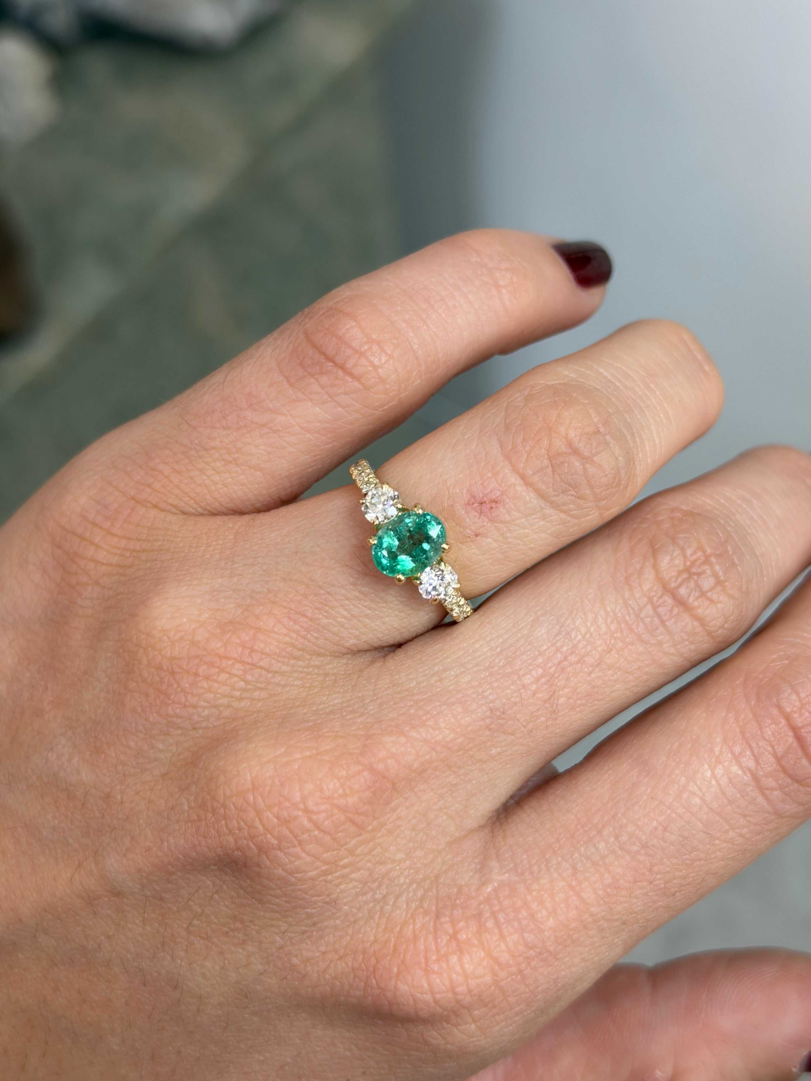 14K gold three-stone ring featuring 2.40tcw oval emerald and round lab diamonds with accent stones, by JR Colombian Emeralds.