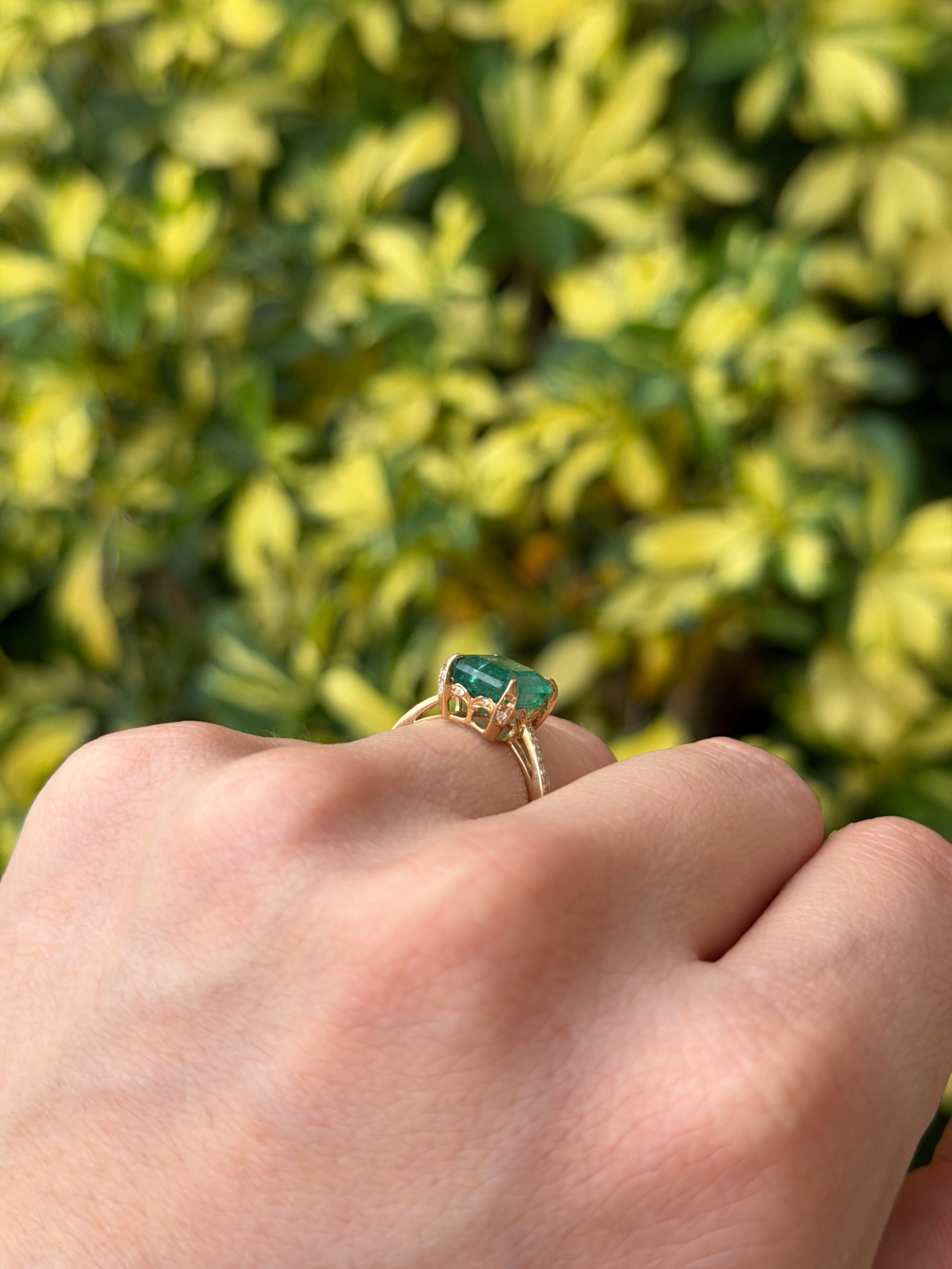 14K gold engagement ring with a 3.50tcw natural emerald center stone, hidden diamonds, and a detailed halo and shank design.