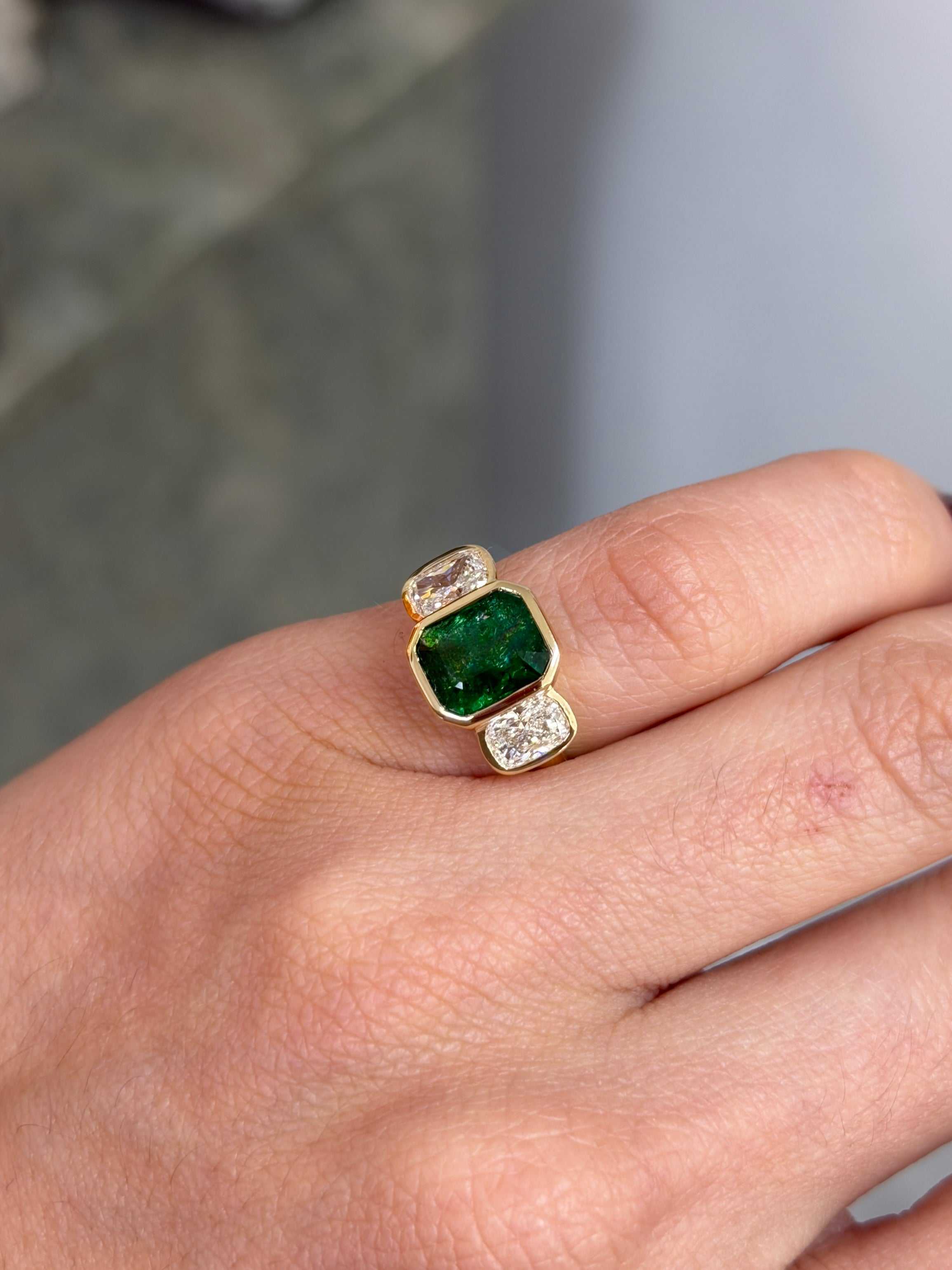 14K gold three stone ring featuring bezel-set emerald and cushion cut lab diamond, totaling 3.70tcw, by JR Colombian Emeralds.