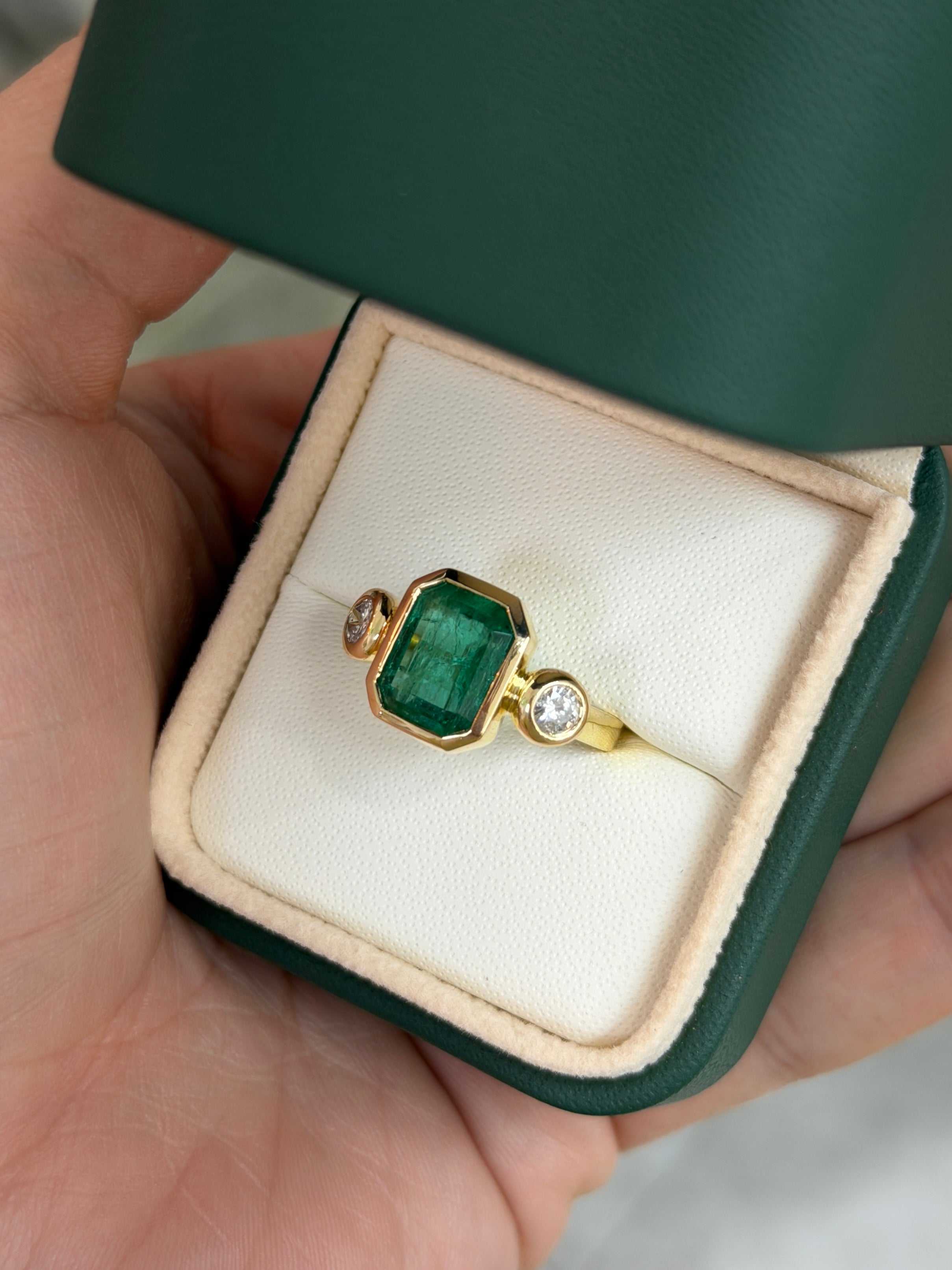 Natural dark emerald and round diamonds three-stone ring by JR Colombian Emeralds, set in 18K gold, featuring sparkling gemstones.