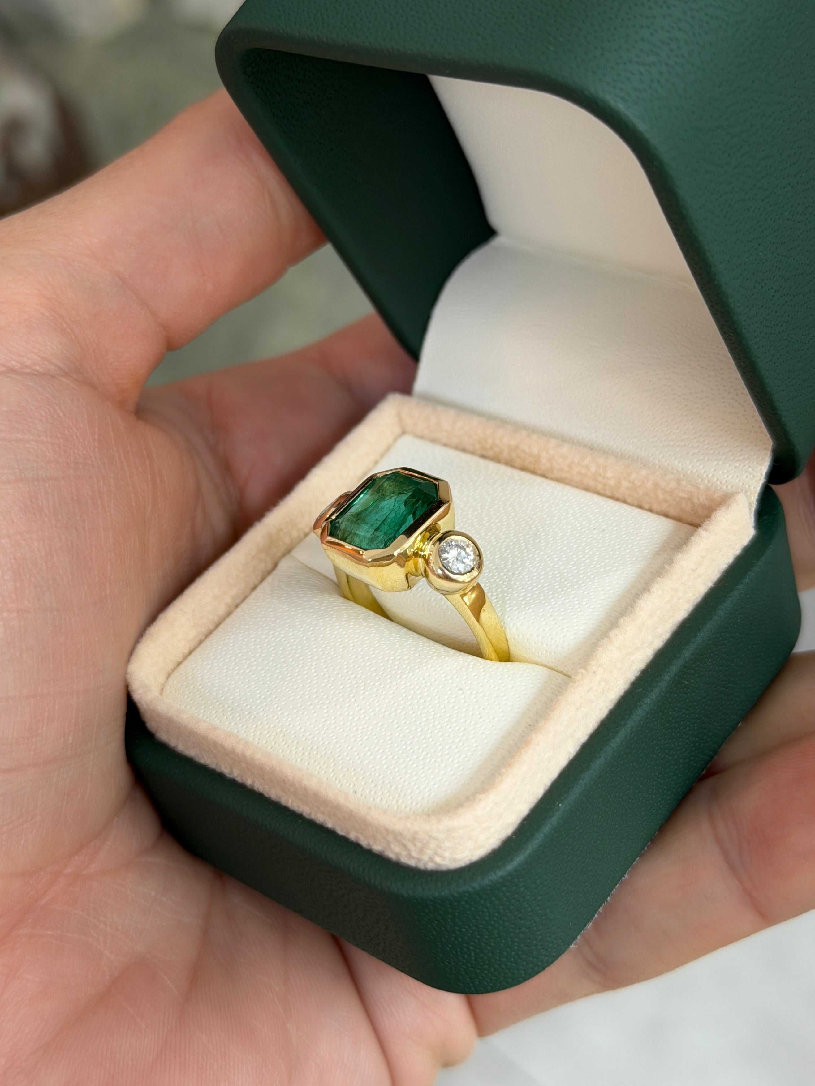 Natural dark emerald and round diamonds three-stone ring in 18K gold by JR Colombian Emeralds, showcasing the gemstone details.