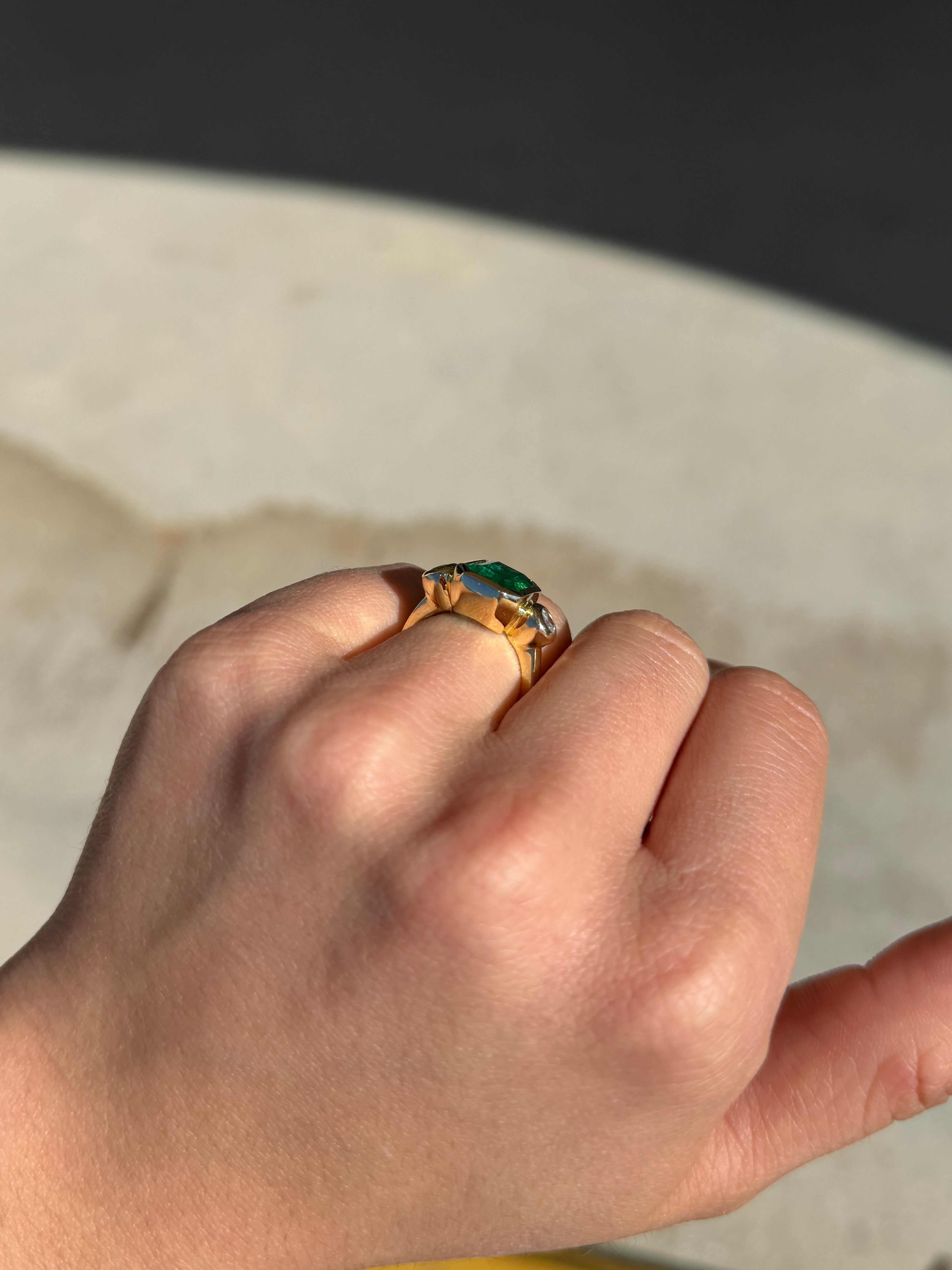 Natural dark emerald and round diamond three-stone ring in 18K gold by JR Colombian Emeralds, showcasing the elegant jewelry design.