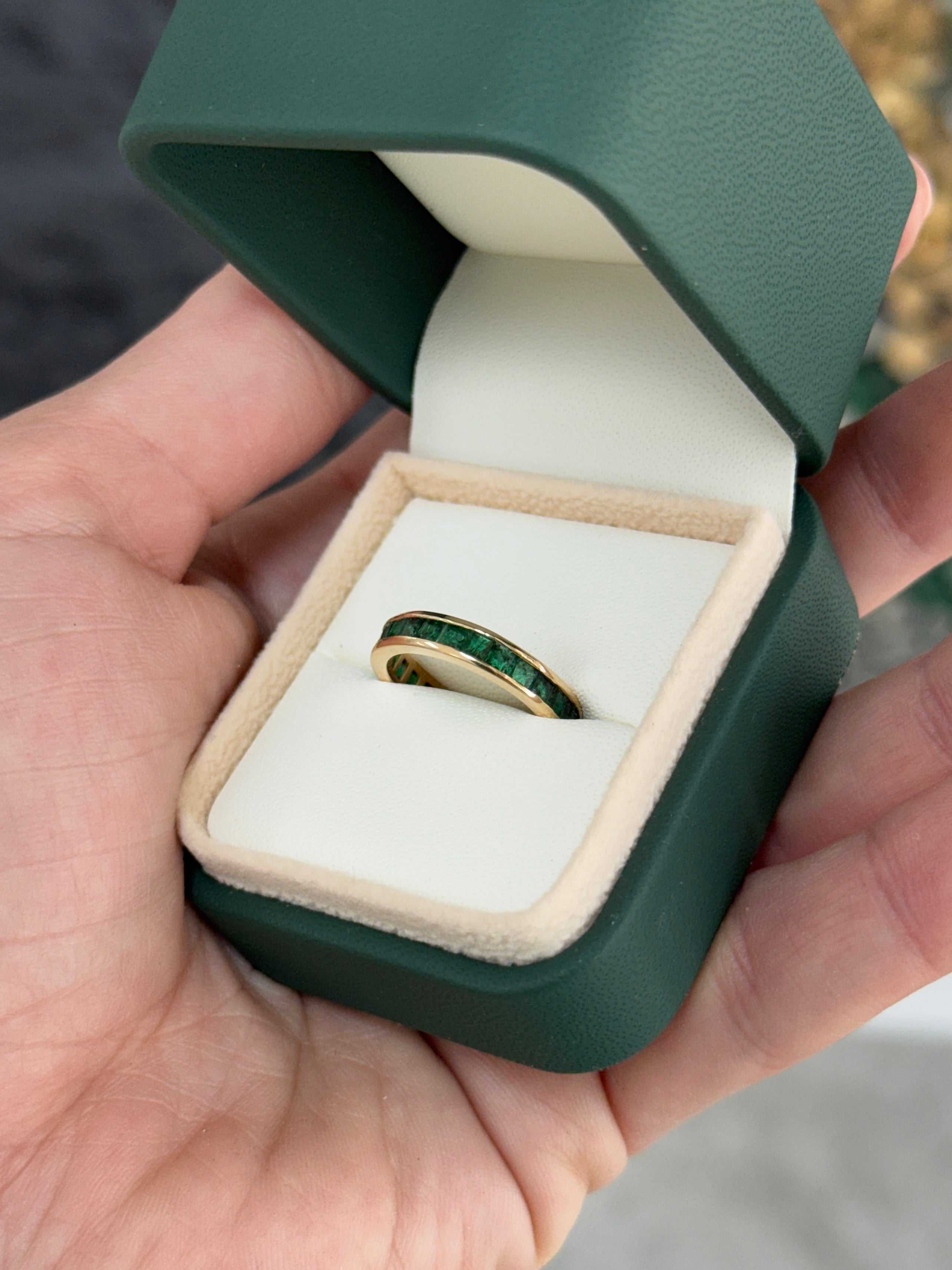JR Colombian Emeralds eternity band with princess cut natural emeralds, channel set, size 6 and 8, showcasing sparkling green gemstones.