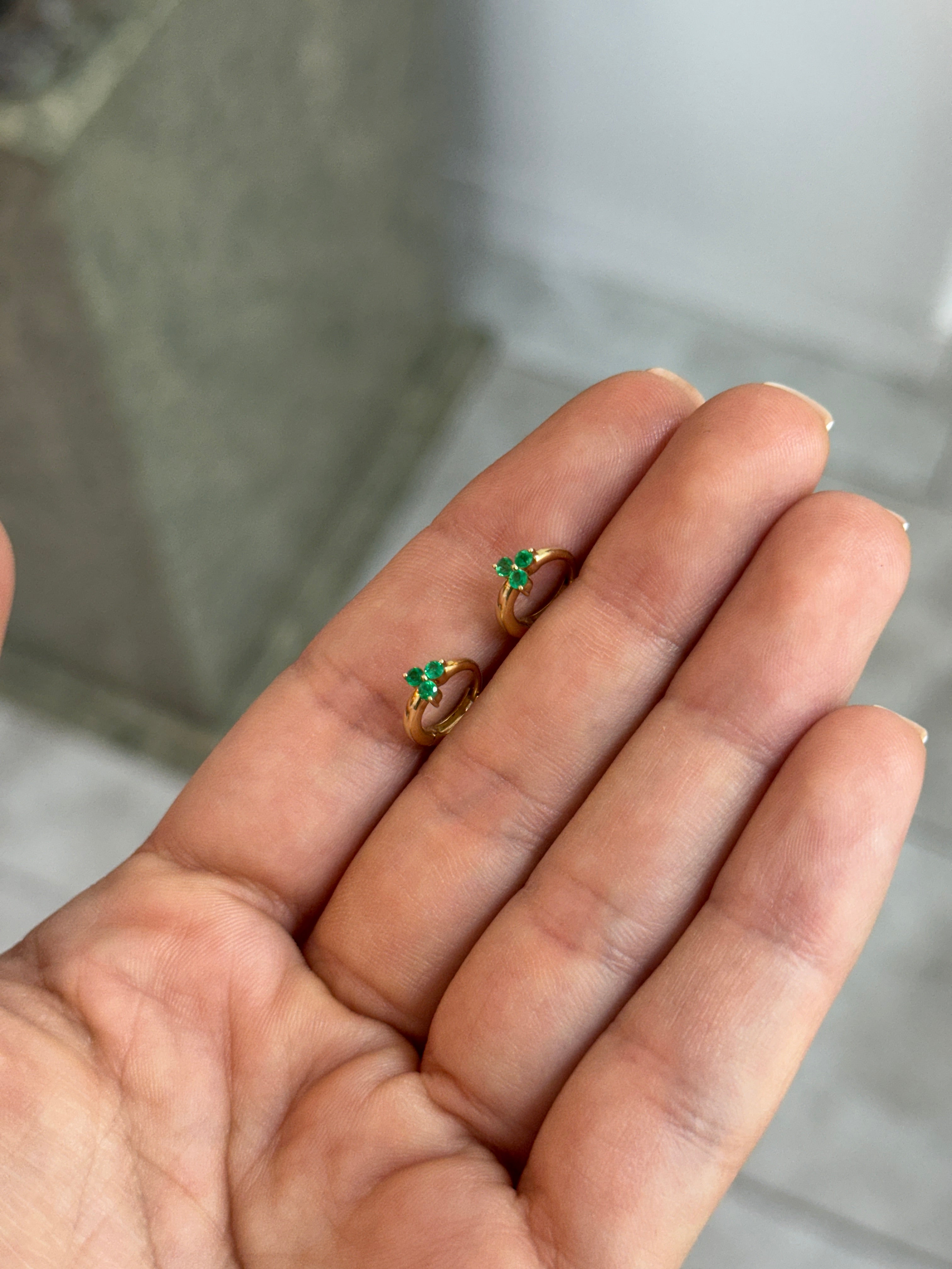 JR Colombian Emeralds 0.22tcw Trinity Earring Huggies in 14K gold, featuring three emerald gemstones and a secure hoop design.