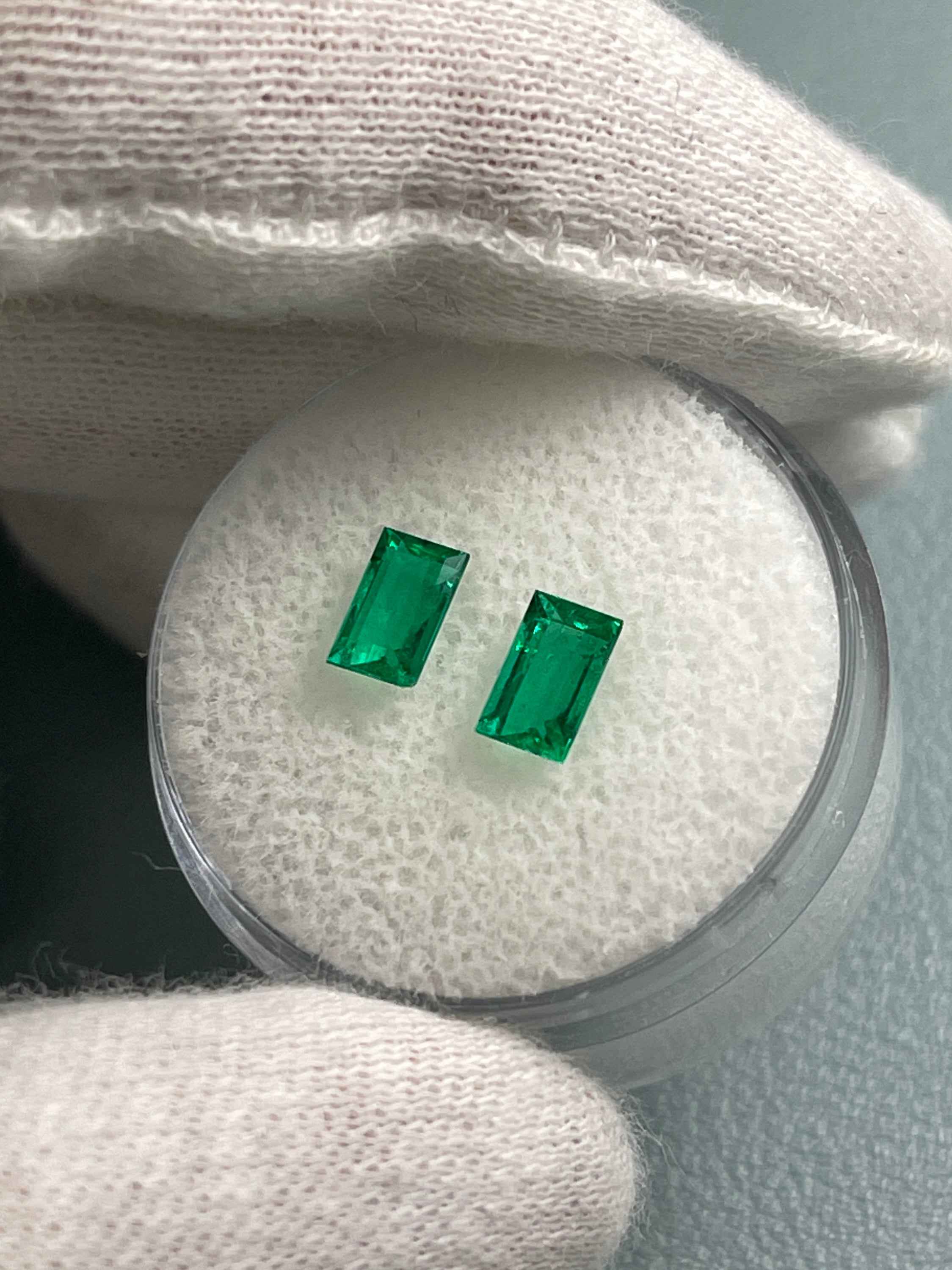 Two matching Colombian emerald baguette cuts, 0.99tcw, showcasing rich green hues and precise 6x3.7mm dimensions.