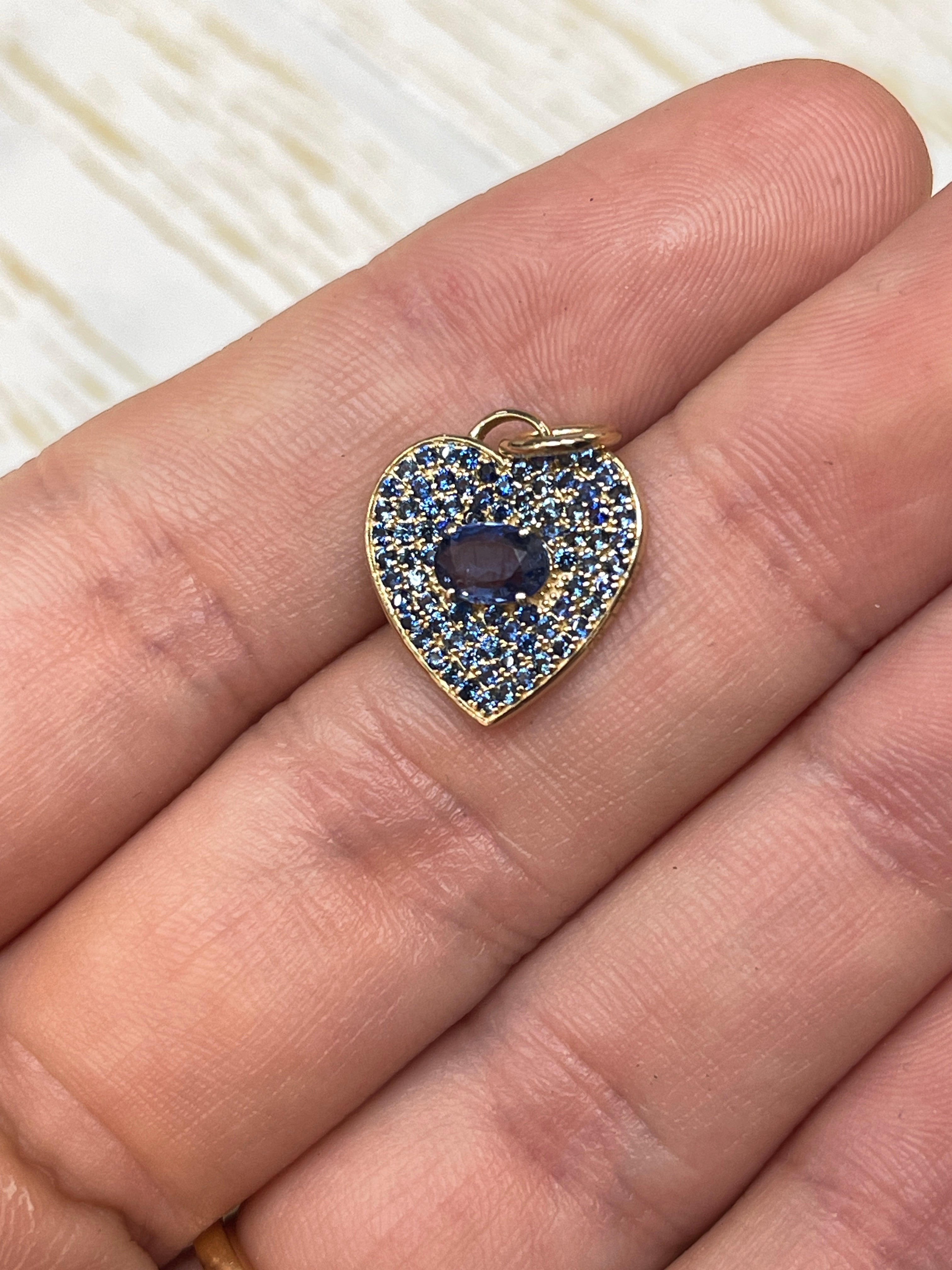 14K gold blue sapphire heart charm pendant with 1.10 carats from JR Colombian Emeralds, showcasing a sparkling blue gemstone.