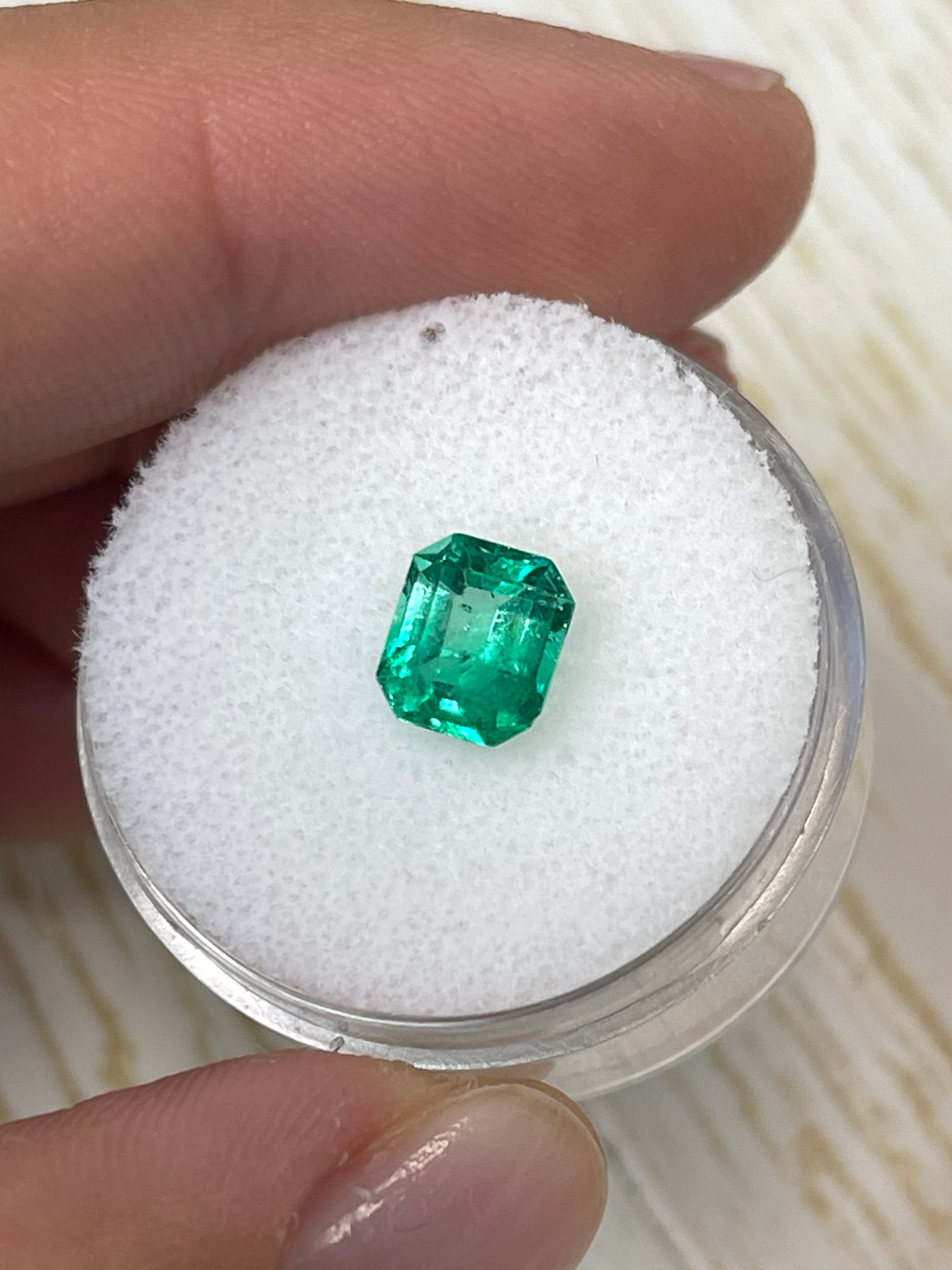 1.20 Carat yellowish green natural Colombian emerald loose gemstone in emerald cut, showcasing vibrant color and clarity.
