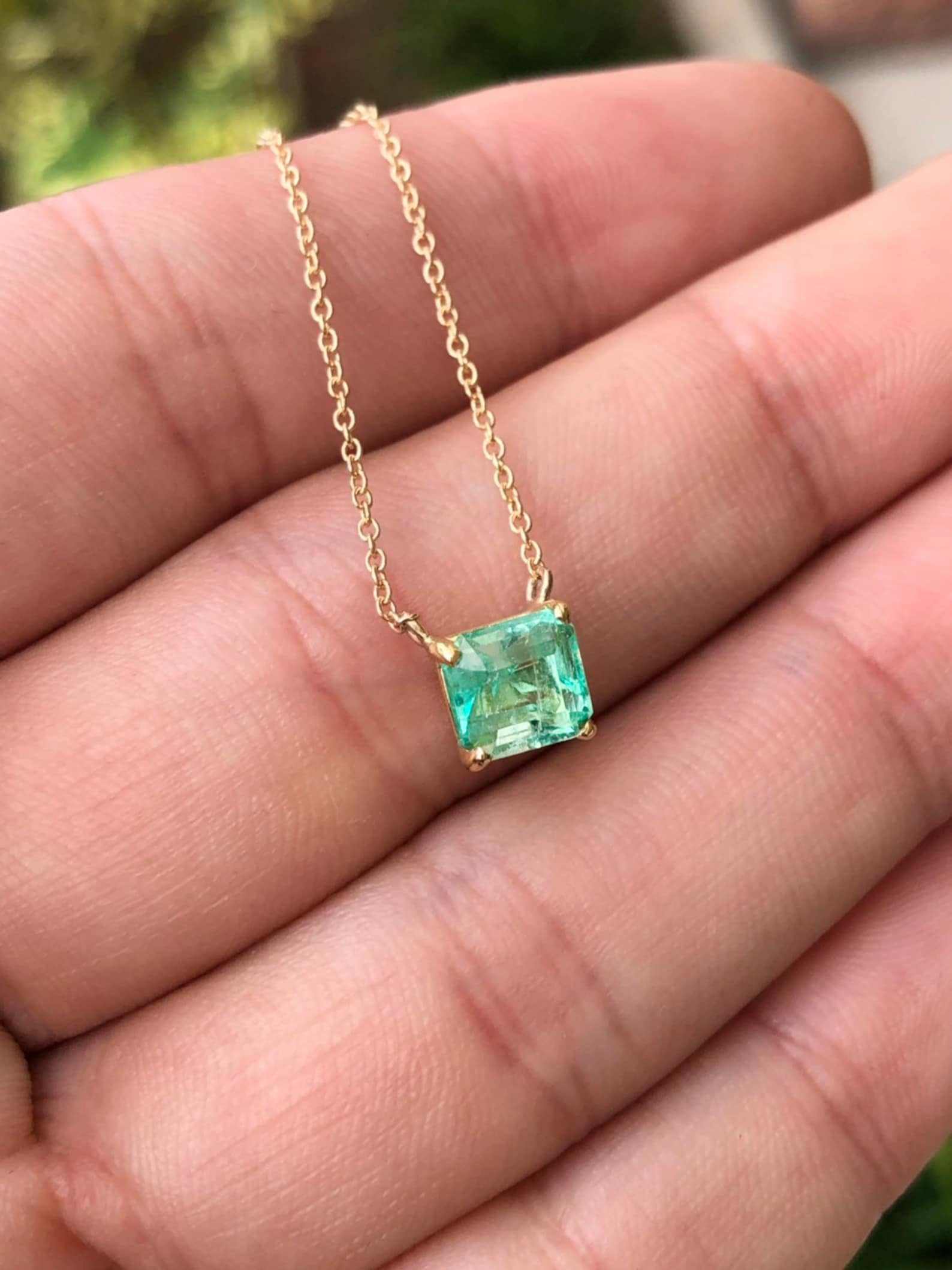 Rich green Colombian emerald solitaire necklace with emerald-cut 1.30 carat emerald set in 14K gold.