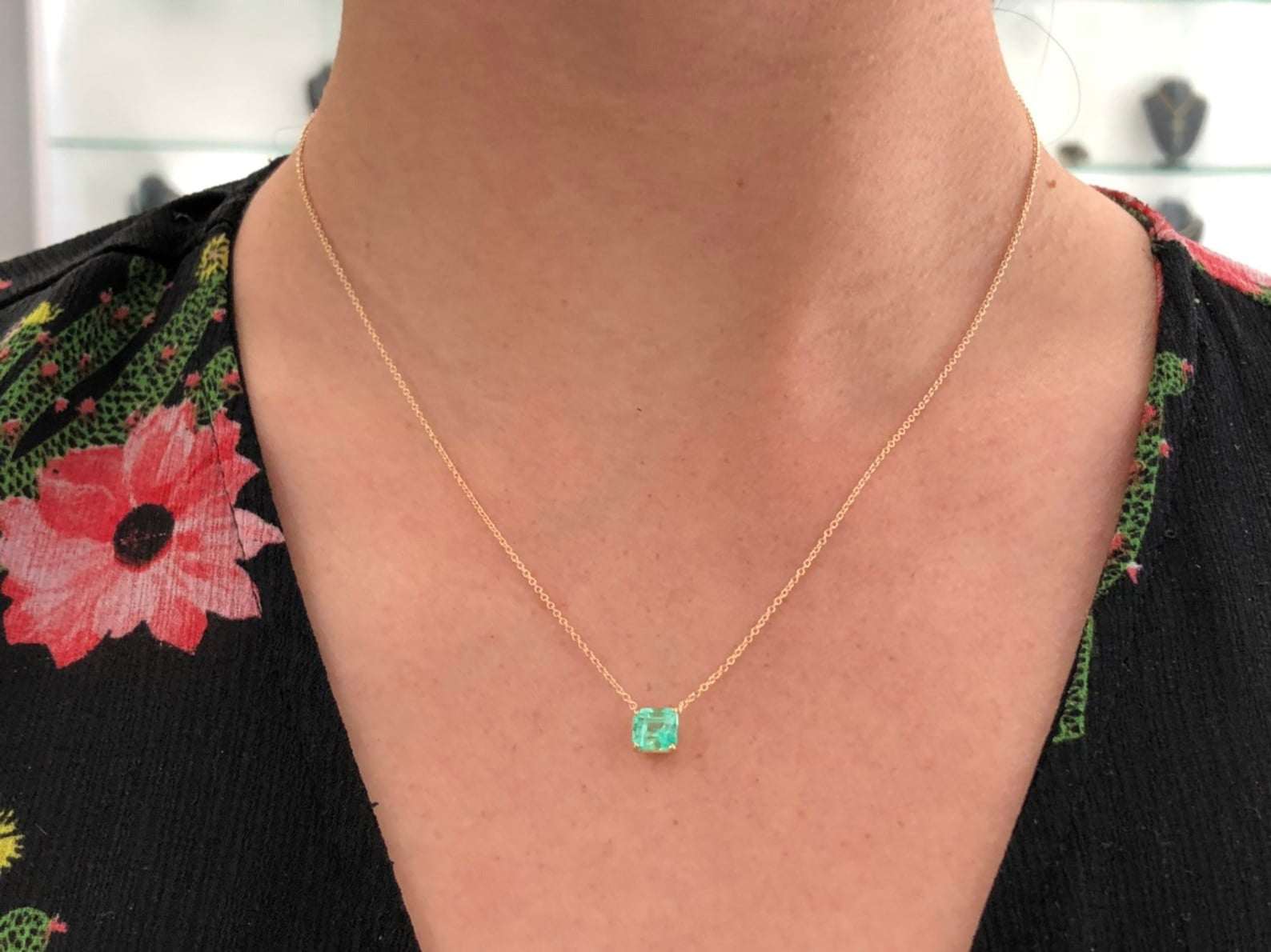 14K necklace featuring a 1.30 carat rich green Colombian emerald in an emerald cut, set in a simple solitaire design.