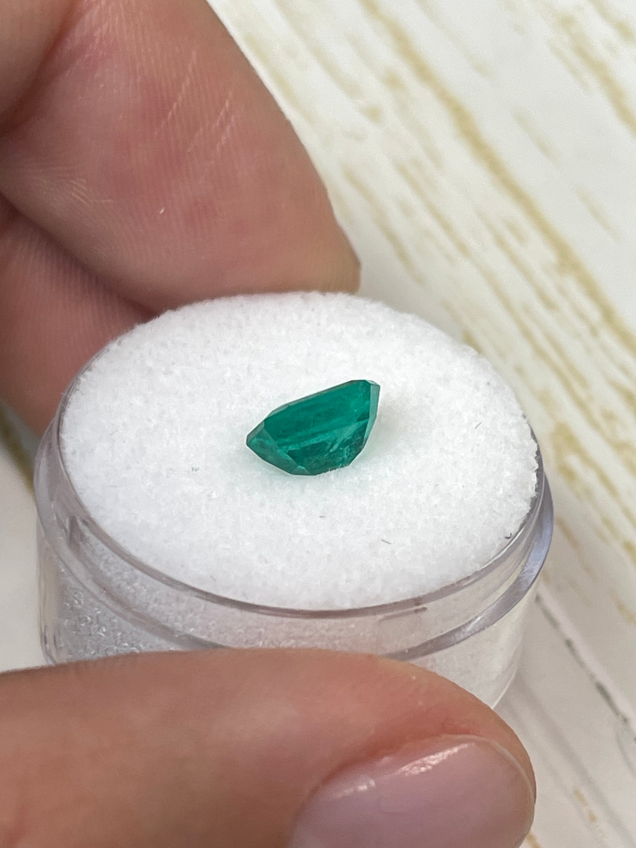Loose 1.31 carat Colombian emerald in an 8x6 emerald cut, showcasing vibrant green color and high-quality clarity.