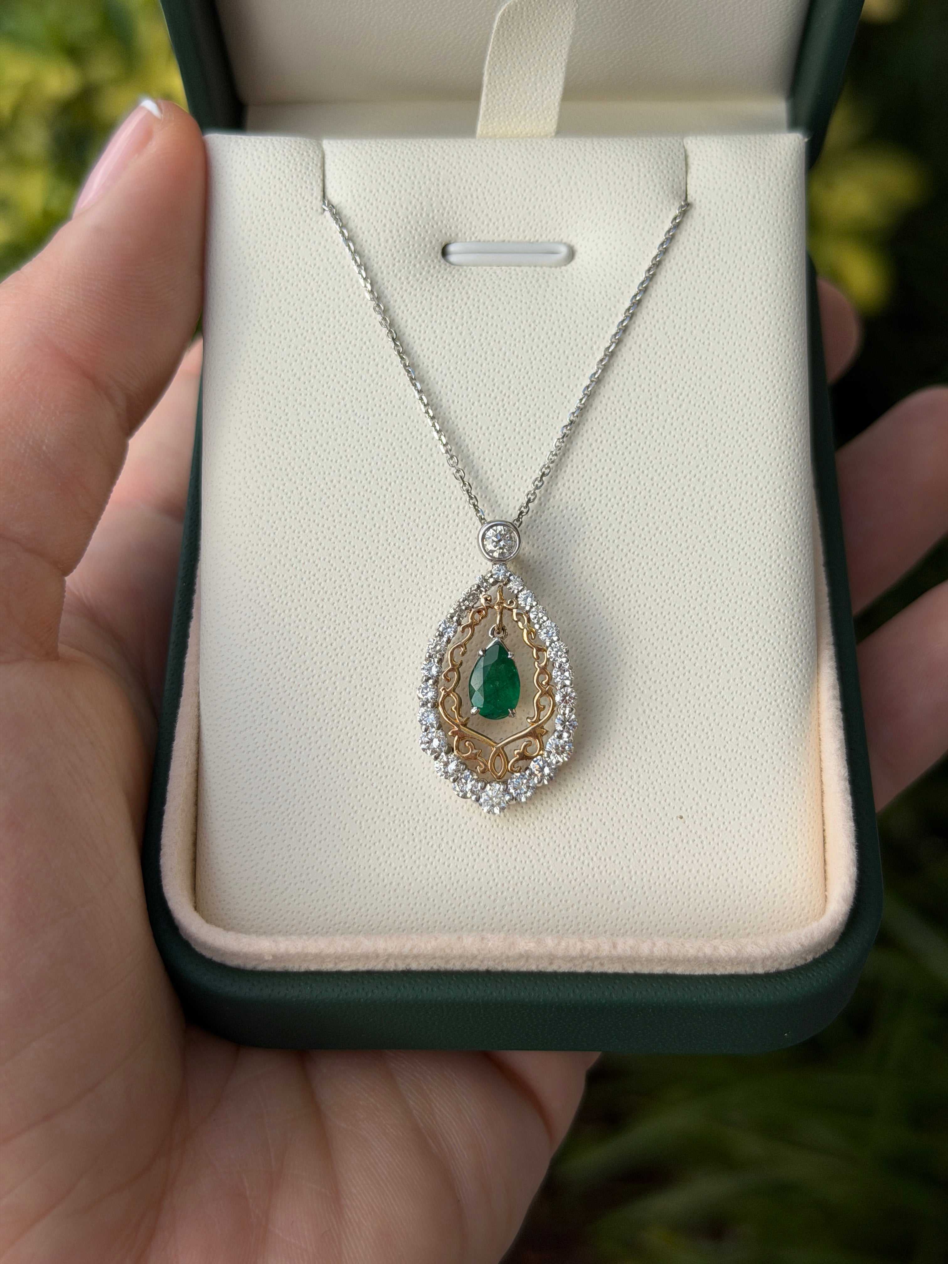 Emerald and diamond two-tone statement necklace with 1.43 carats, featuring pear-shaped emeralds and diamonds in 14K gold.