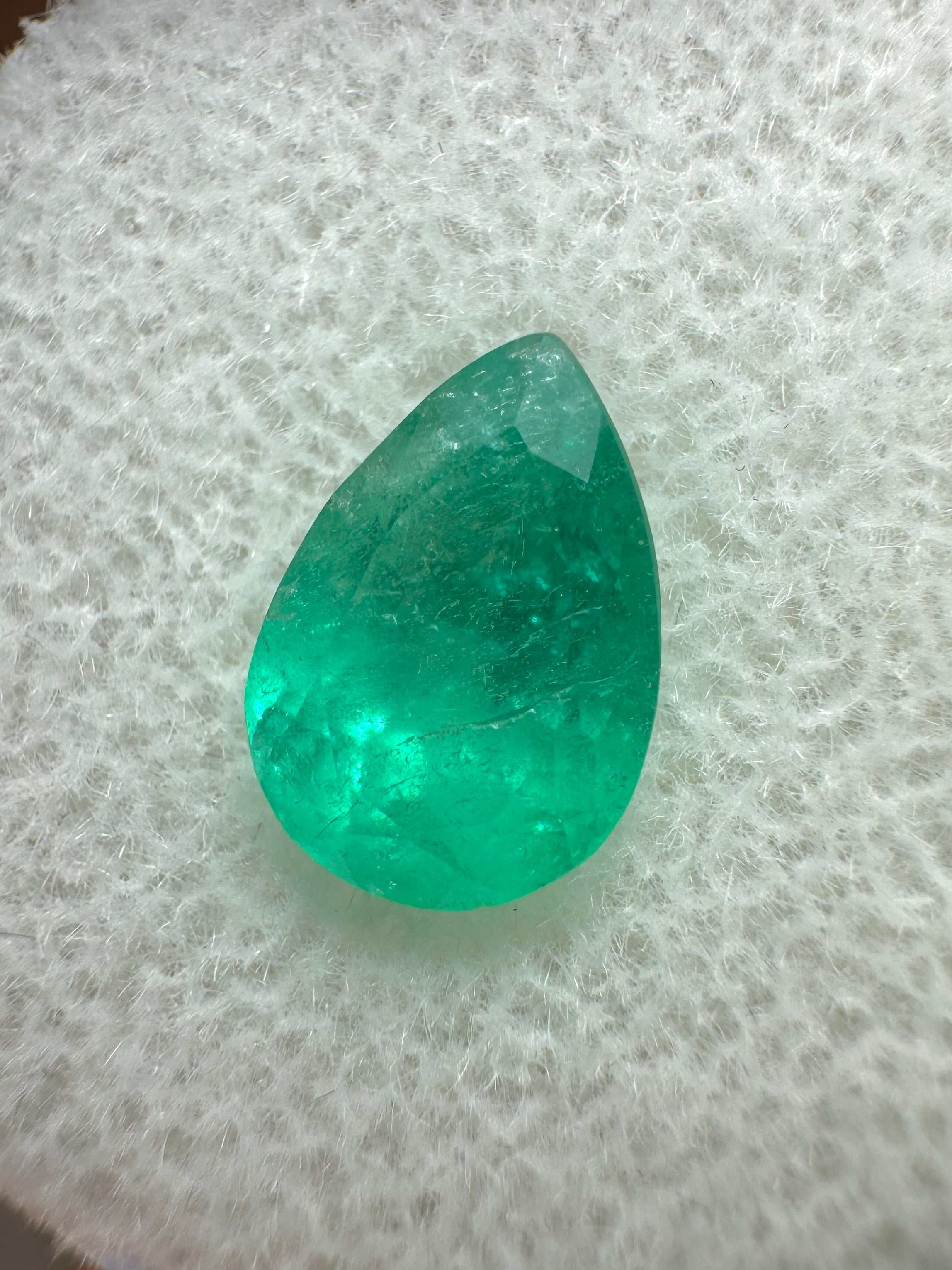 Medium green 1.58 carat natural Colombian emerald loose gemstone in pear cut, showcasing vibrant color and clarity.