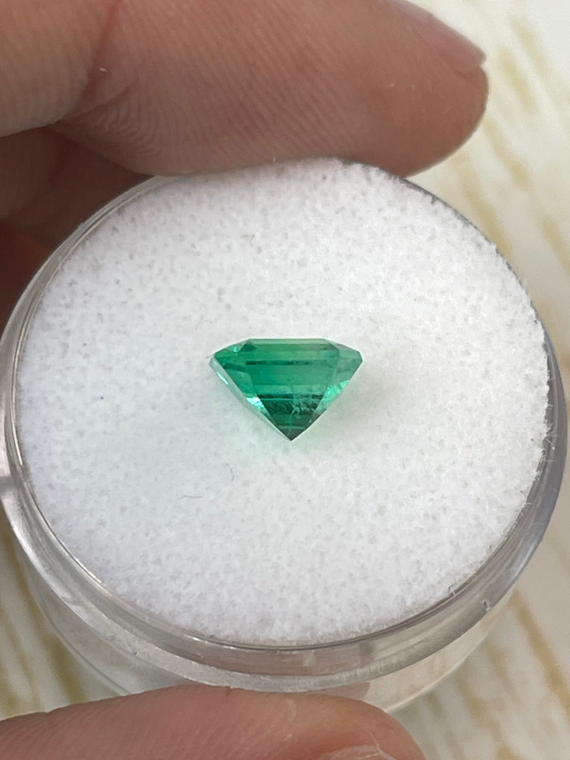 Yellowish green 1.64 carat Asscher cut natural Colombian emerald gemstone, unset and displayed with precise dimensions.