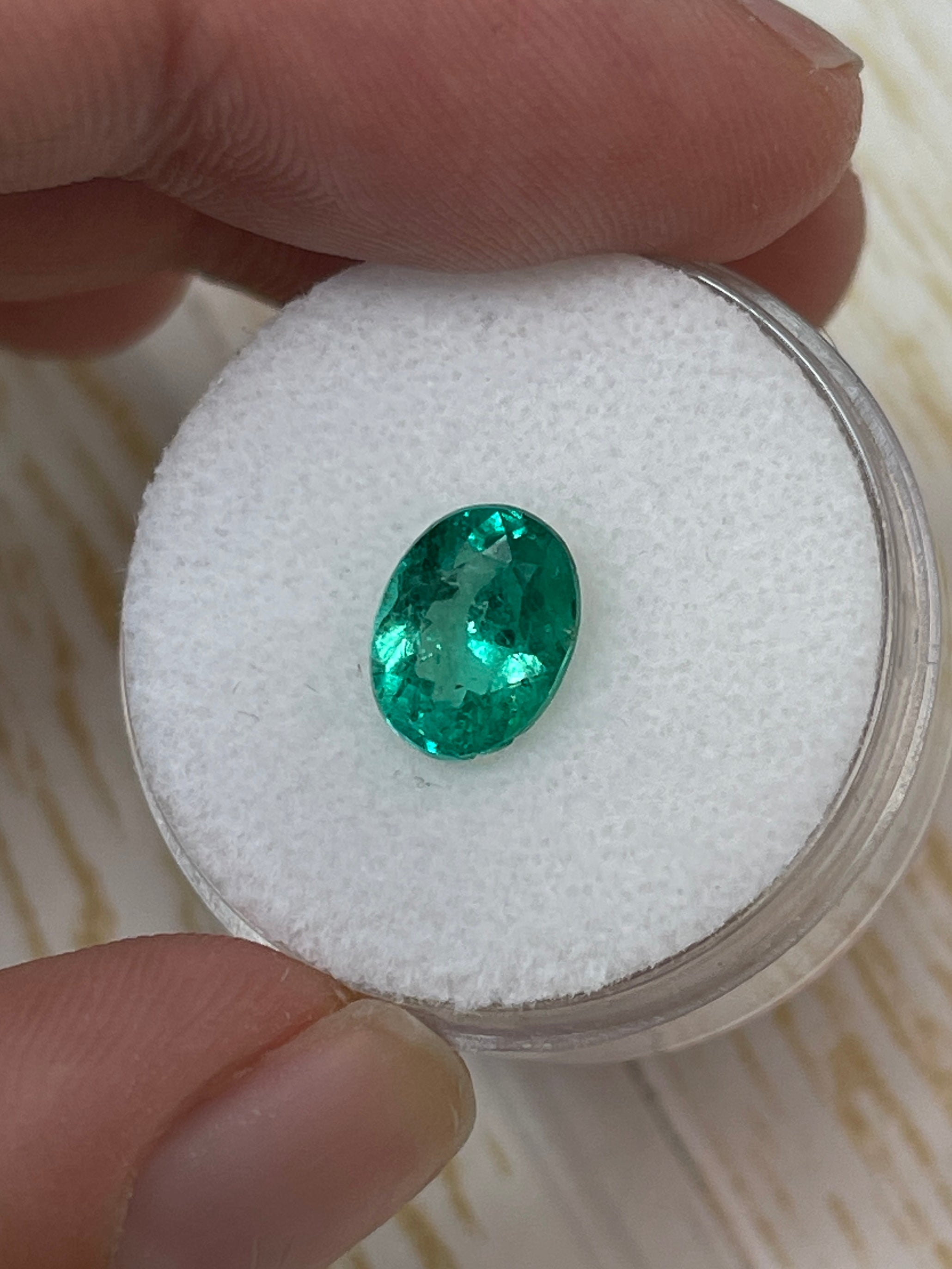 1.64 carat oval cut green natural Colombian emerald loose gemstone from JR Colombian Emeralds on a white background.