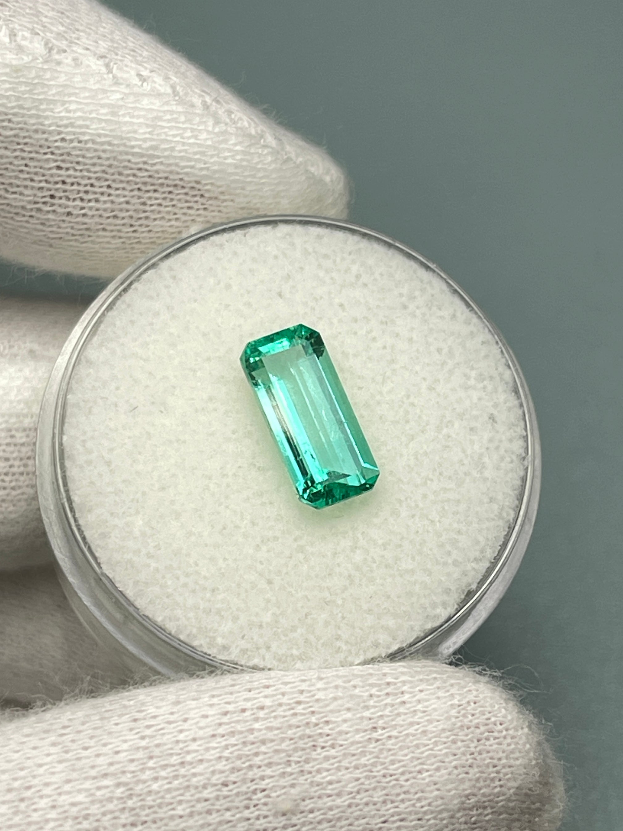 Crystalline 1.65 Carat elongated Colombian emerald loose gemstone with emerald cut, natural and vibrant green color.