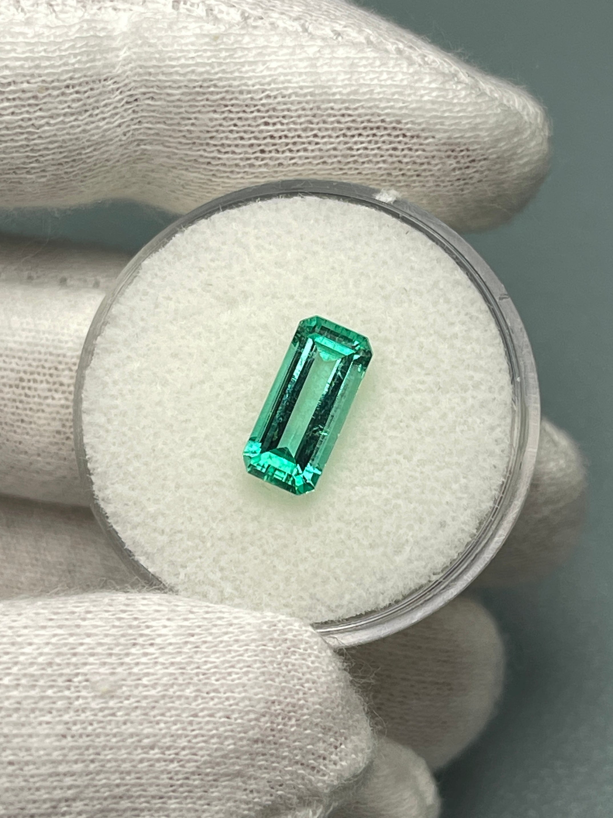 Natural 1.65 carat Colombian emerald loose gemstone, elongated emerald cut with crystalline clarity, showcased by JR Colombian Emeralds.