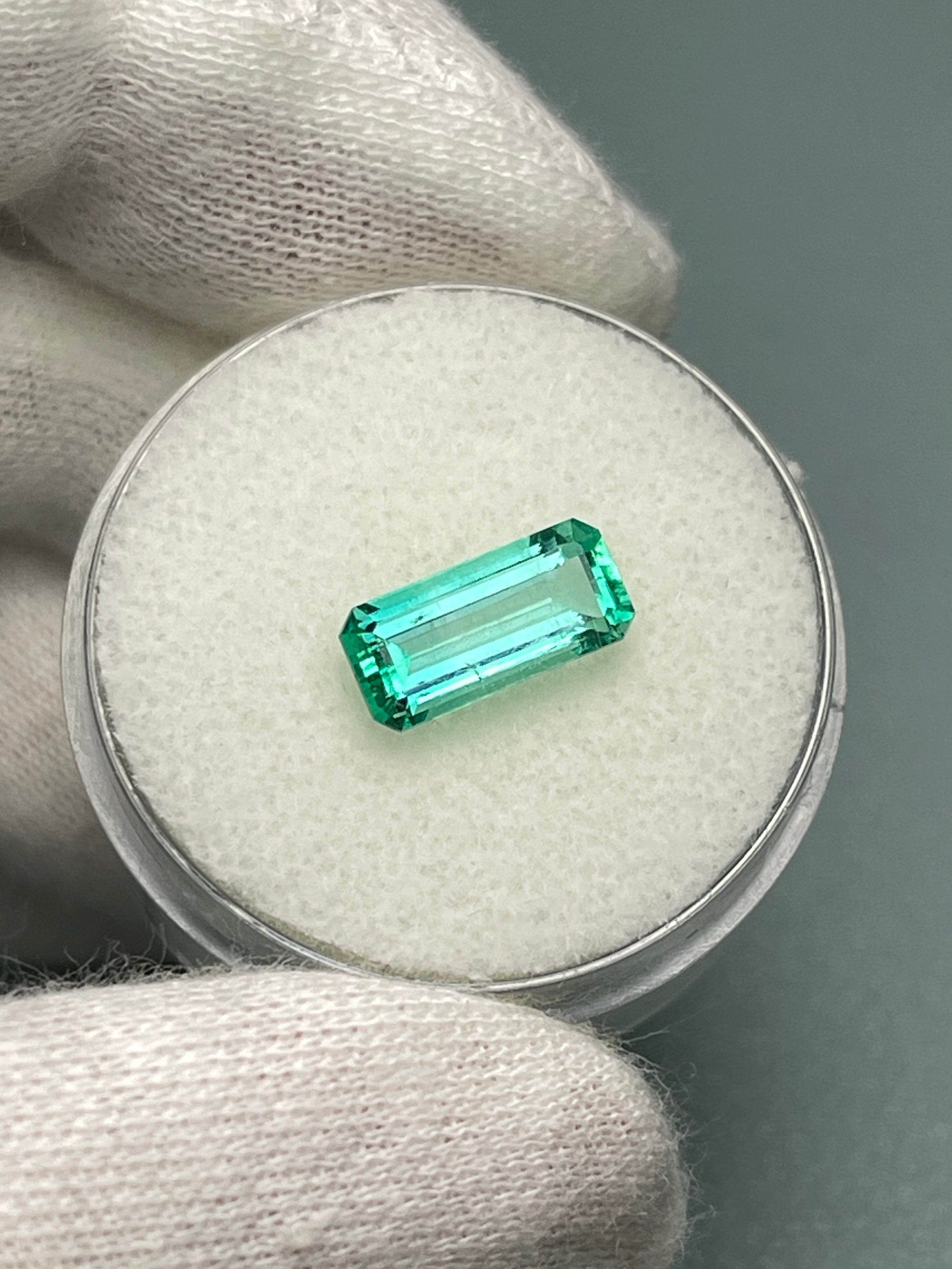 Crystalline 1.65 carat natural Colombian emerald loose gemstone in elongated emerald cut, showcasing vibrant green color and clarity.
