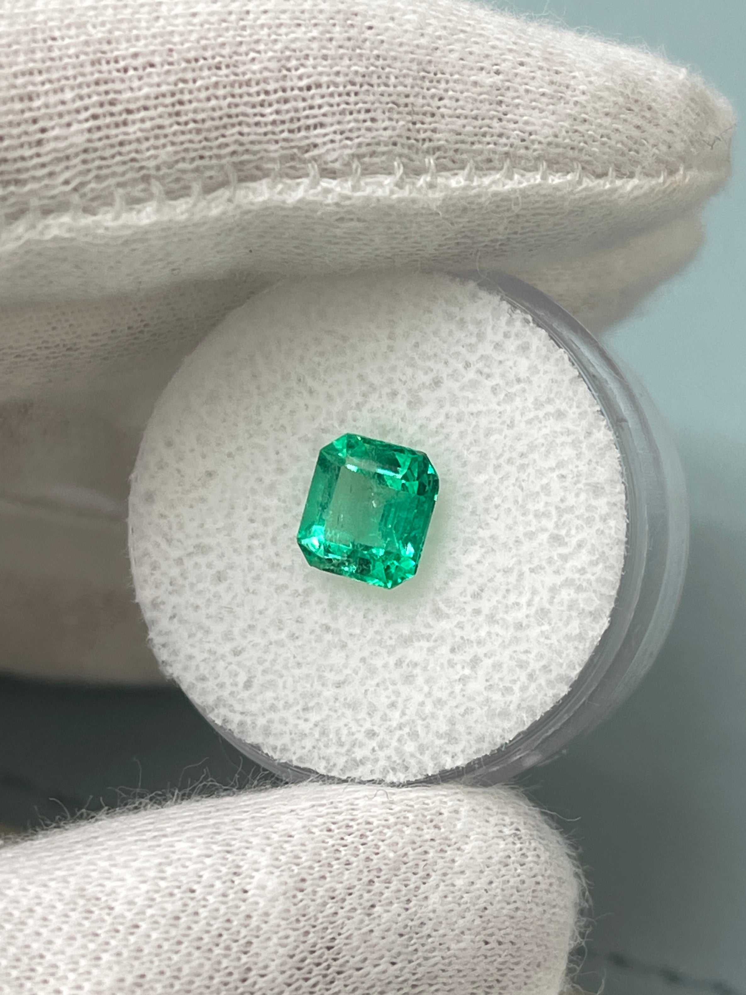 1.68 carat yellowish green Colombian emerald in Asscher cut, showcasing crystalline clarity and natural unset design.