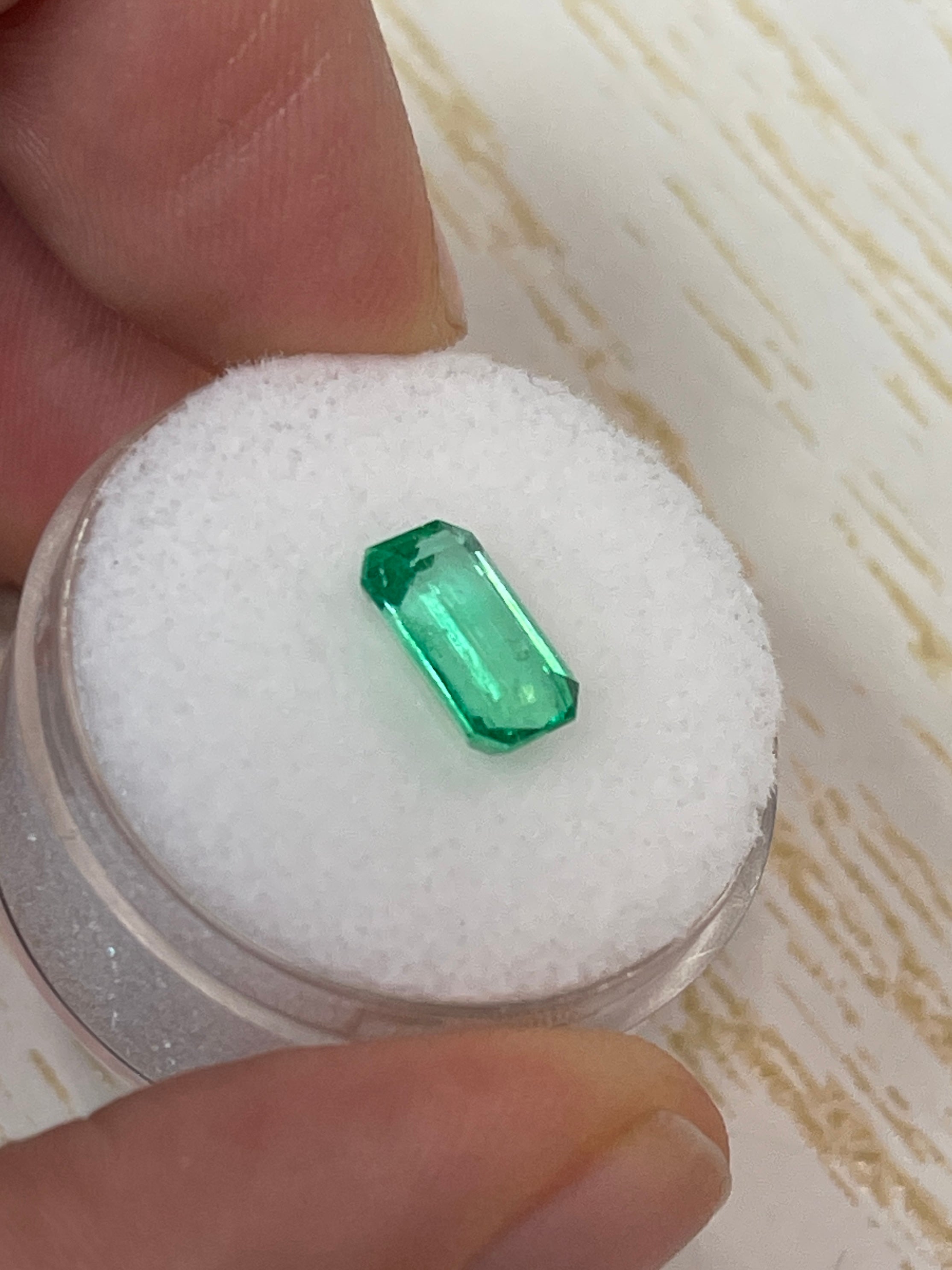 Yellowish green 1.68 carat natural Colombian emerald in emerald cut, showcasing clarity and vibrant color.