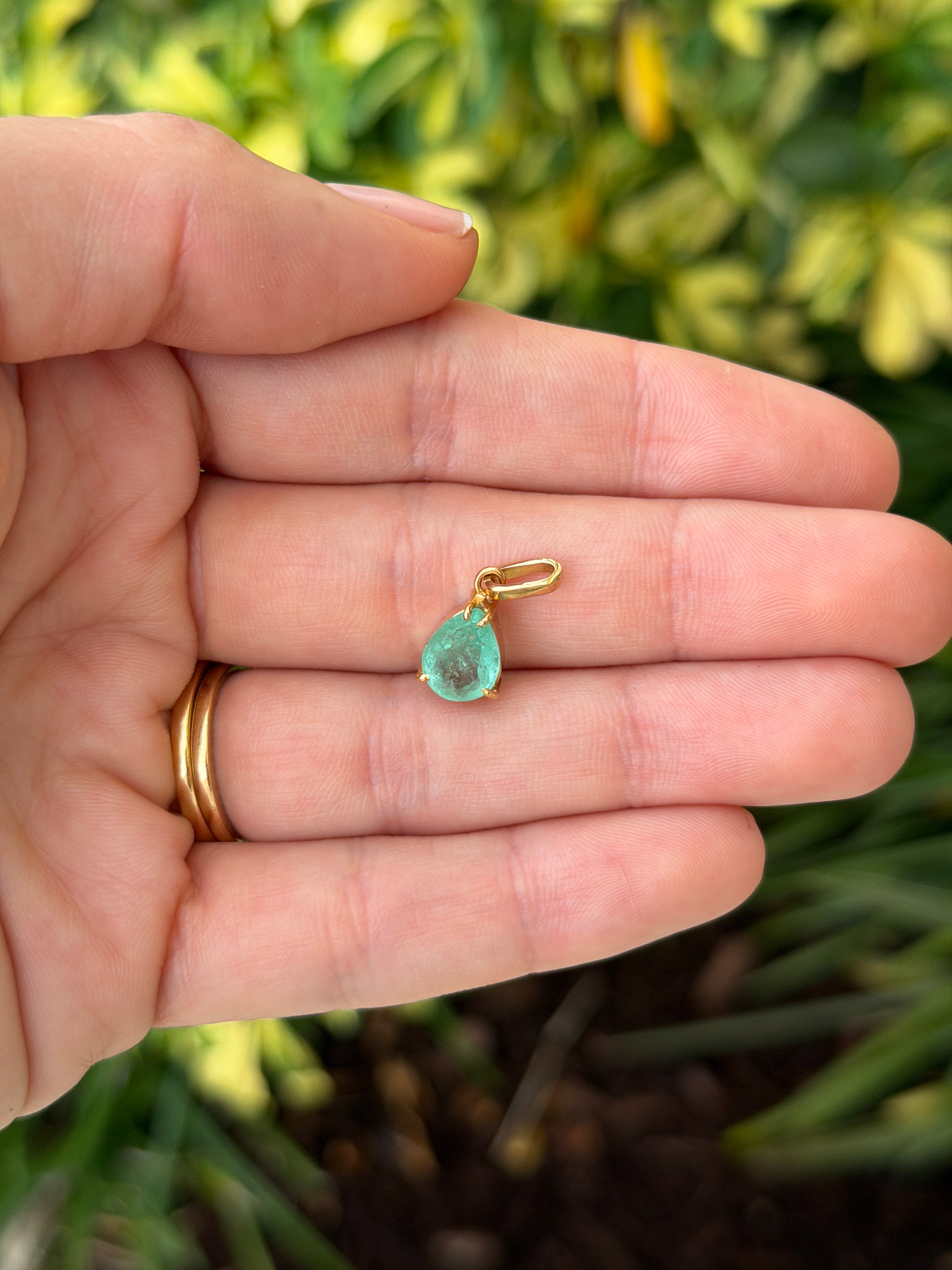 Light green Colombian emerald pear cut solitaire necklace featuring a 1.80 carat emerald, displayed on a delicate chain.