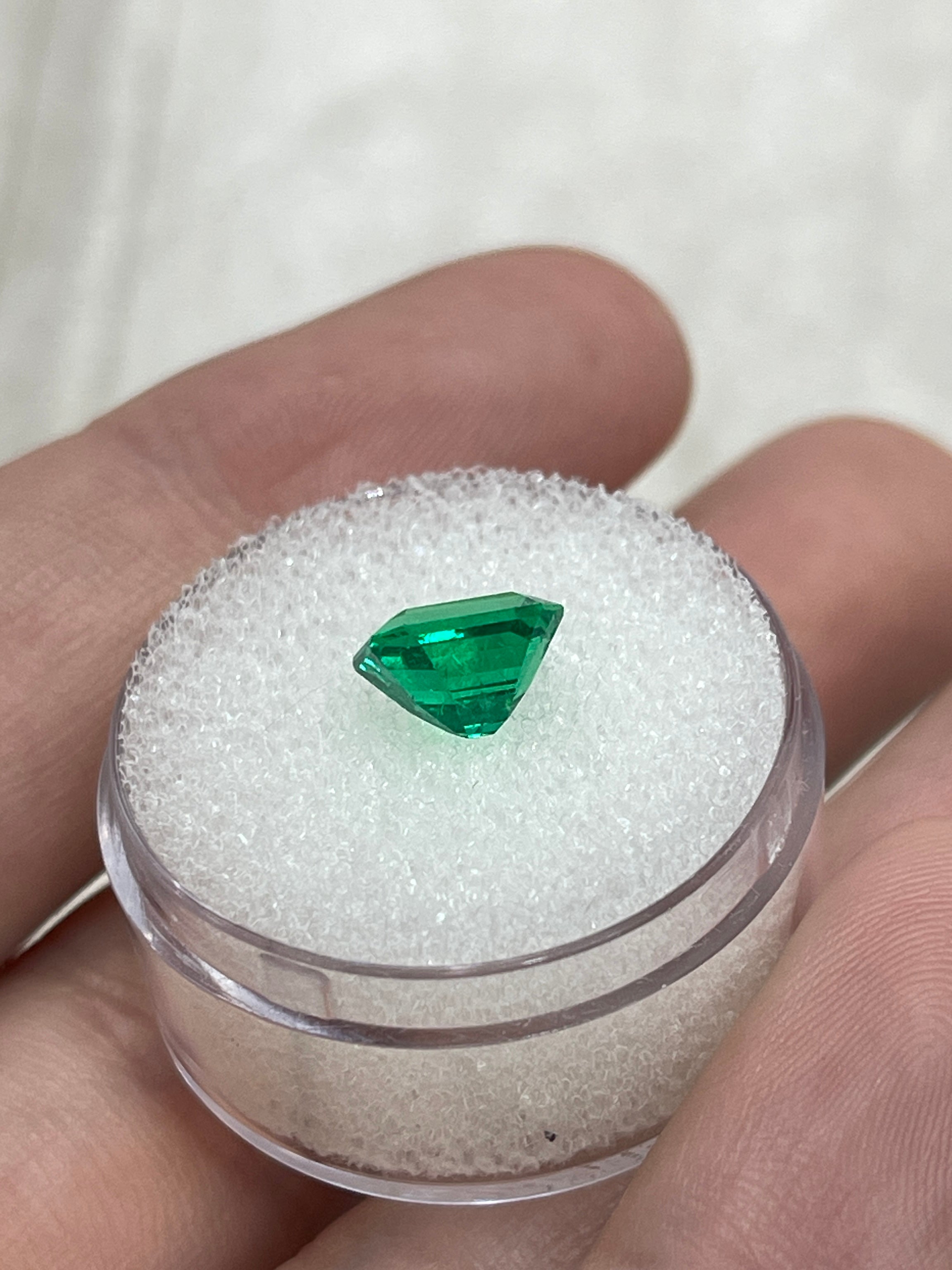 Bright 1.82 carat vivid yellowish green Colombian emerald in an emerald cut, showcasing its vibrant color and clarity.