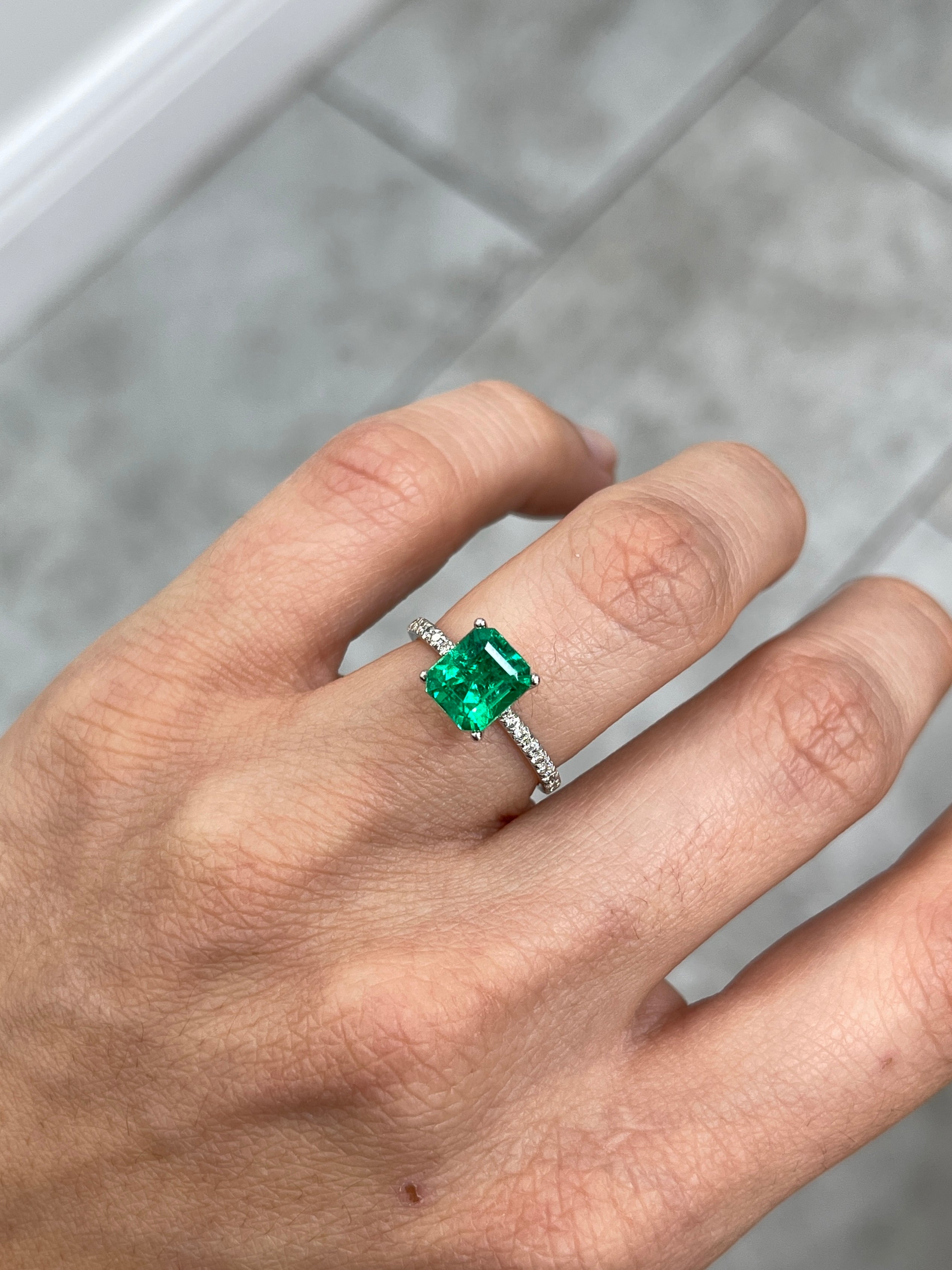 Vivid yellowish-green 1.82 carat Colombian Emerald cut loose gemstone, showcasing its vibrant color and emerald shape.