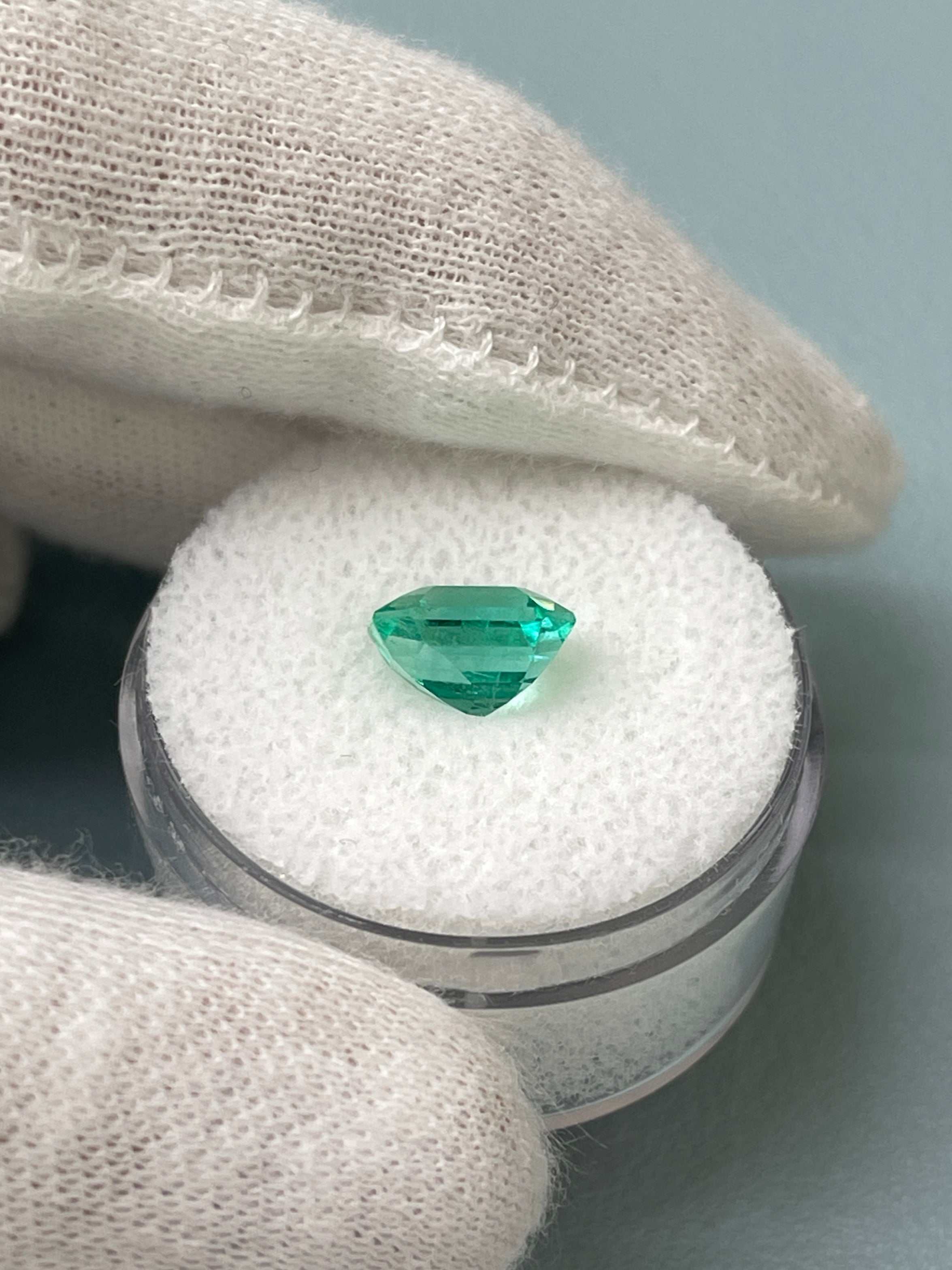 1.92 carat bluish green Colombian emerald loose gemstone in an emerald cut, showcased with a bright, glowing appearance.