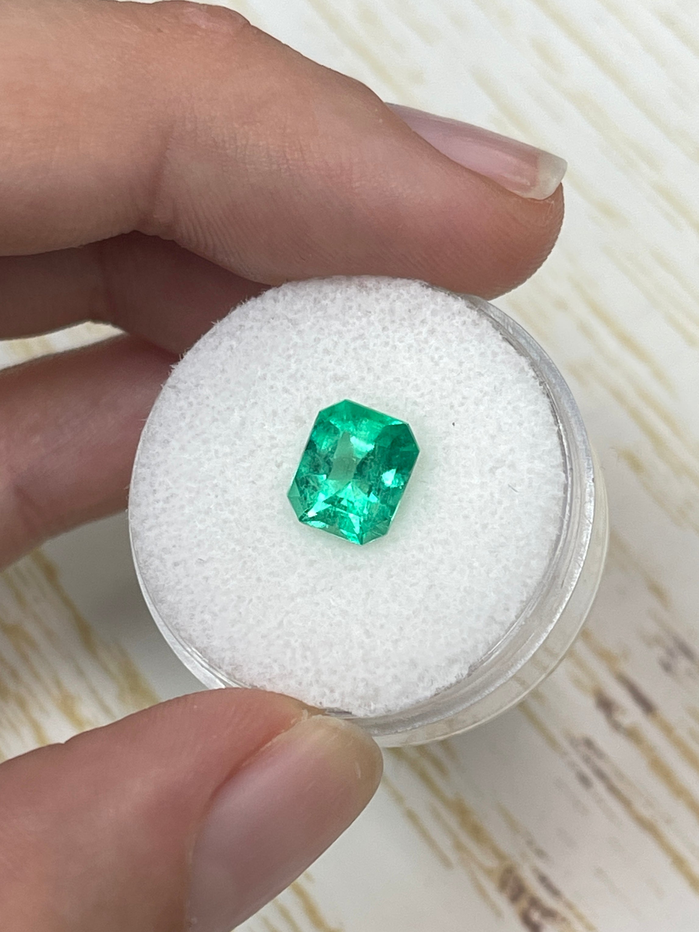 1.92 carat vivacious Muzo green Colombian emerald loose gemstone in an emerald cut, natural and vibrant green color, from JR Colombian Emeralds.