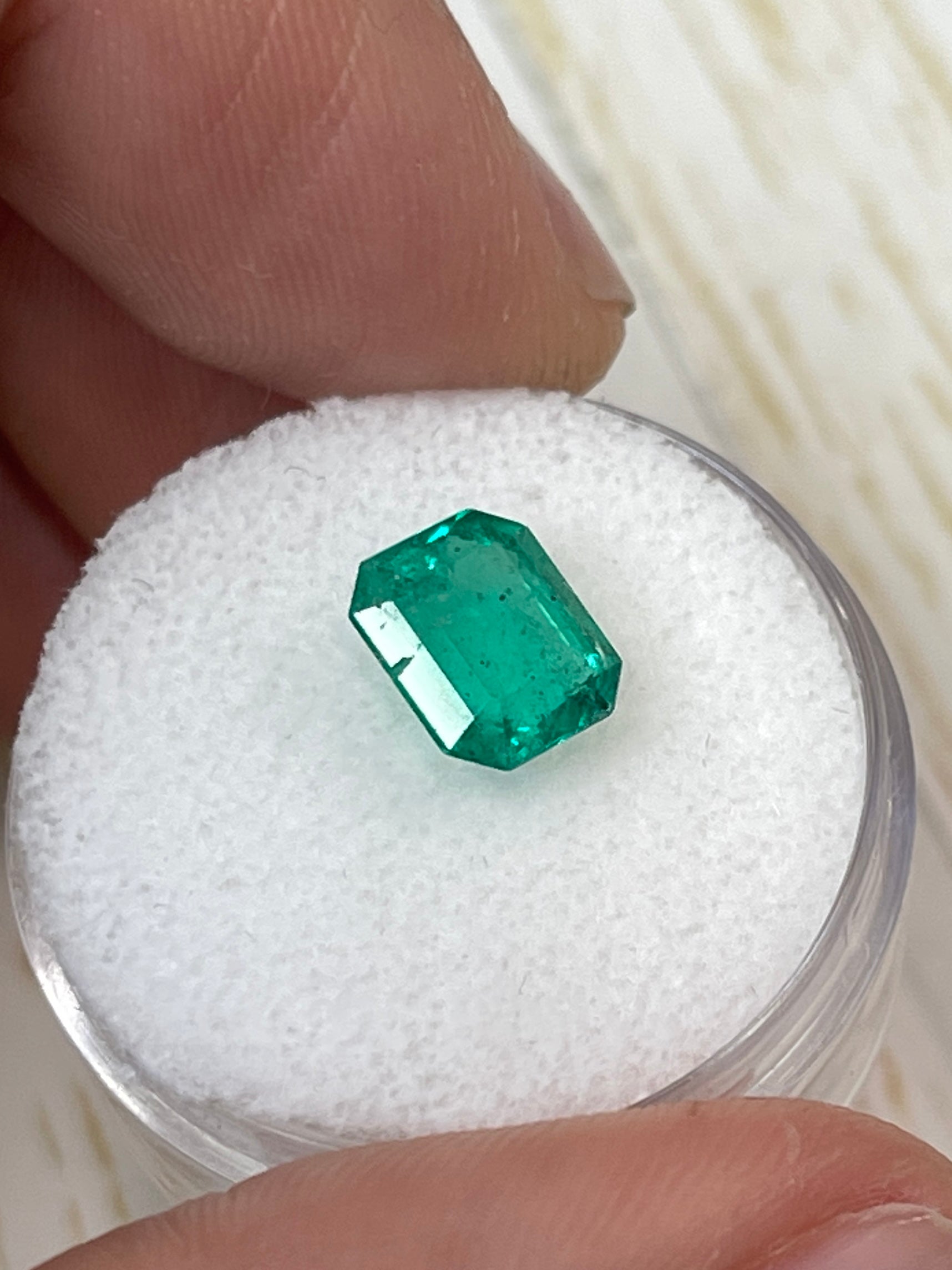 Freckled green 1.94 carat Colombian emerald loose gemstone in emerald cut, natural and vibrant, by JR Colombian Emeralds.