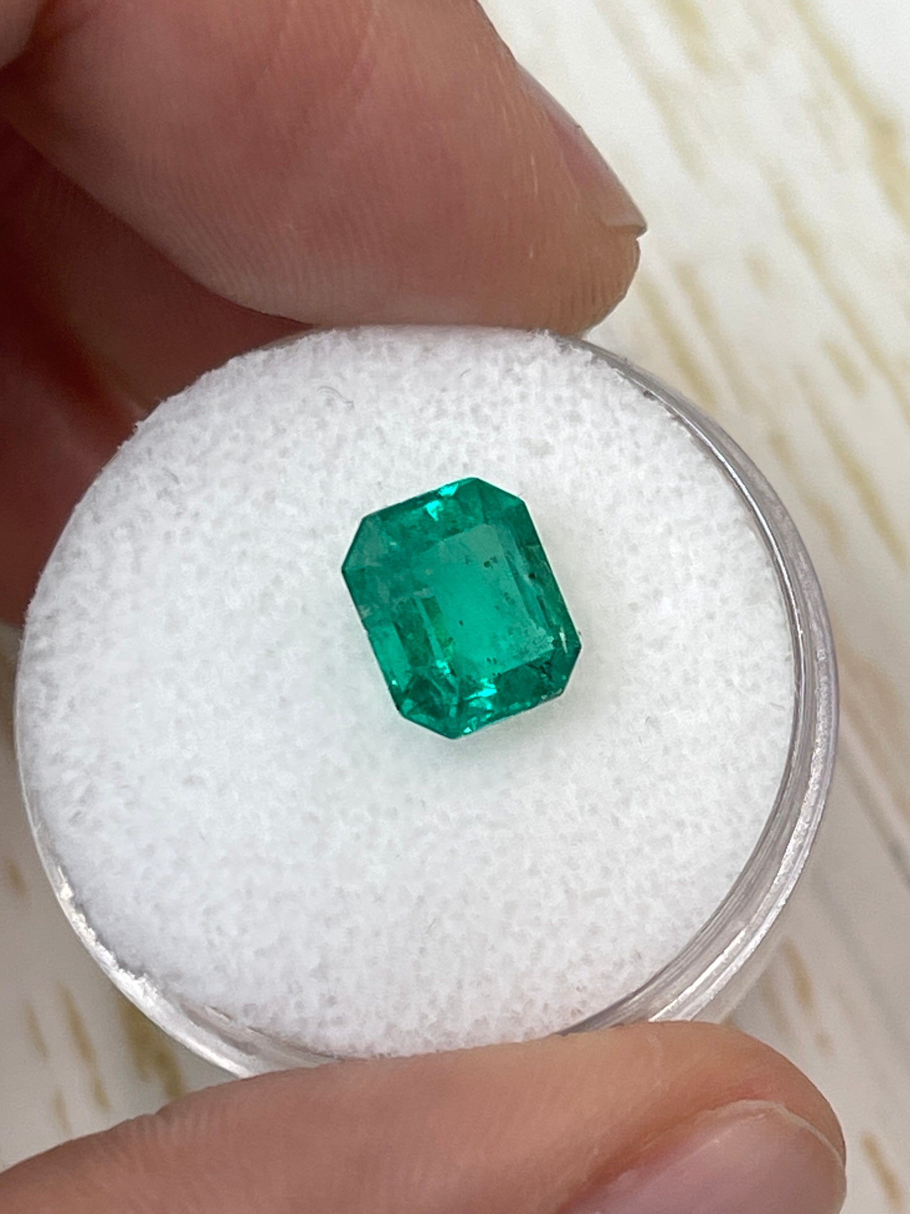 Freckled green 1.94 carat natural Colombian emerald loose stone in emerald cut, 8.5x7mm, from JR Colombian Emeralds.