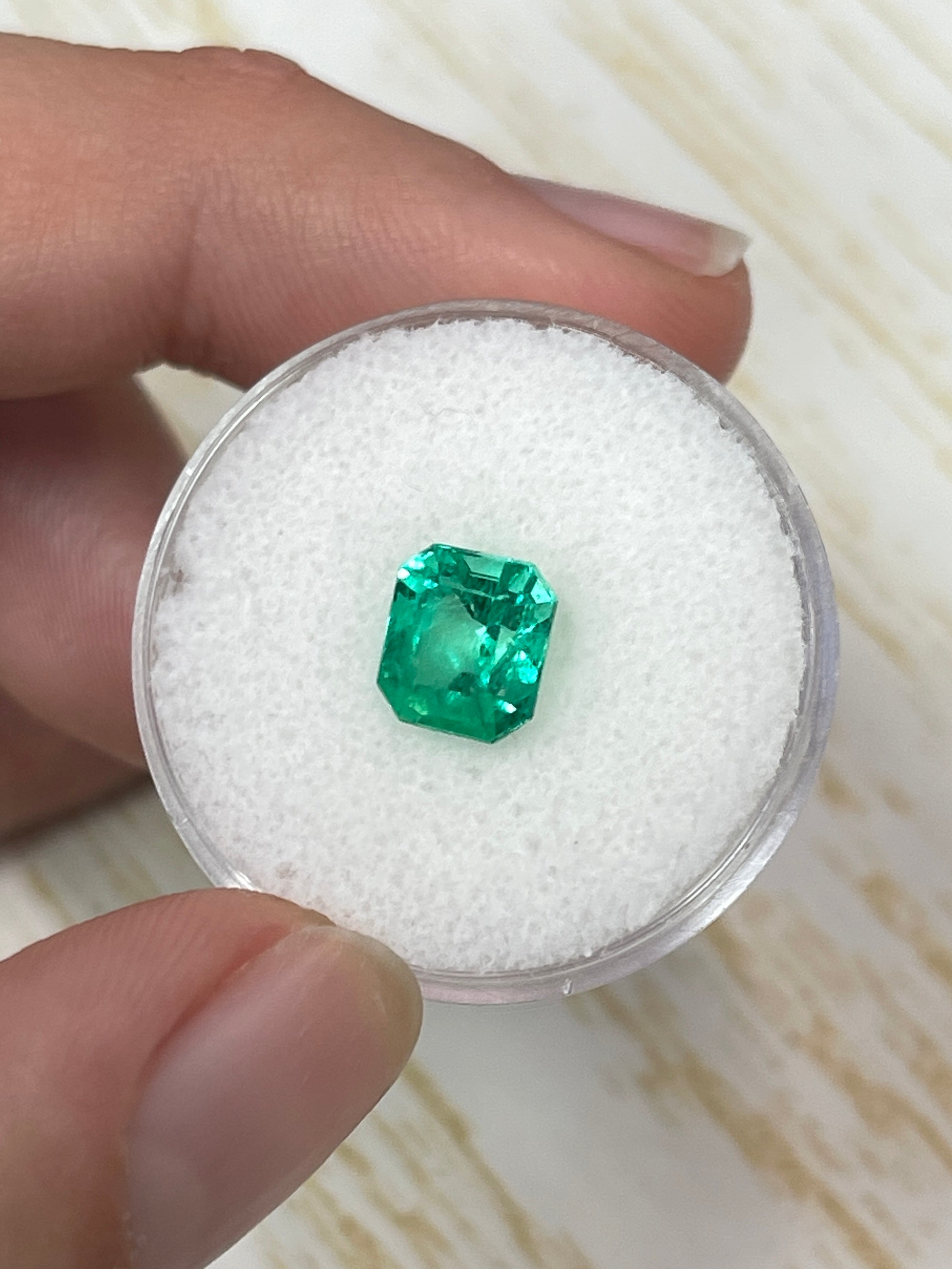 Vivid green 1.96 carat Colombian emerald loose gemstone in an emerald cut, showcasing natural clarity and glowing color.