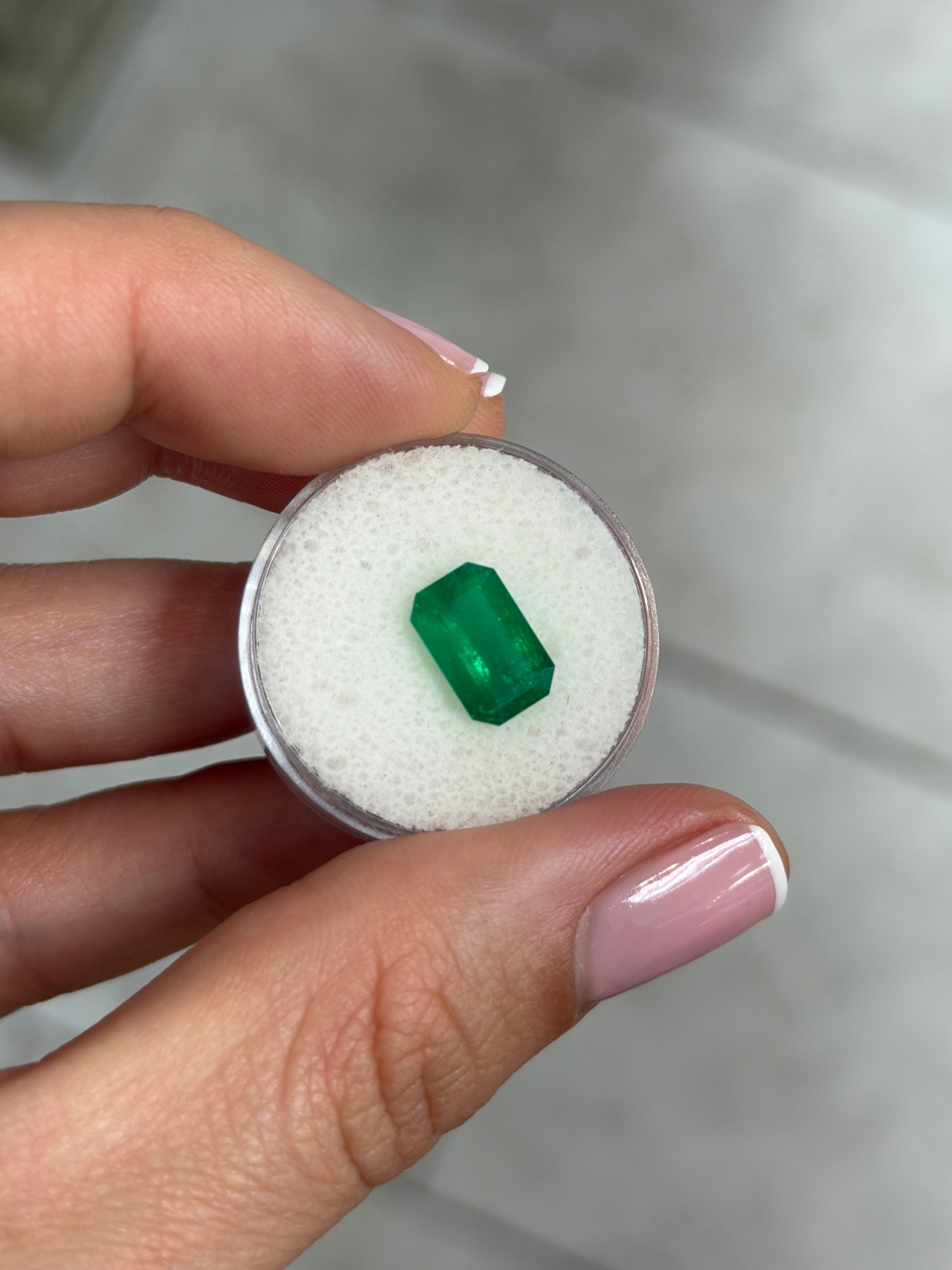 Deep jungle green 2.40 carat natural Colombian emerald in elongated emerald cut, showcasing rich color and clarity.