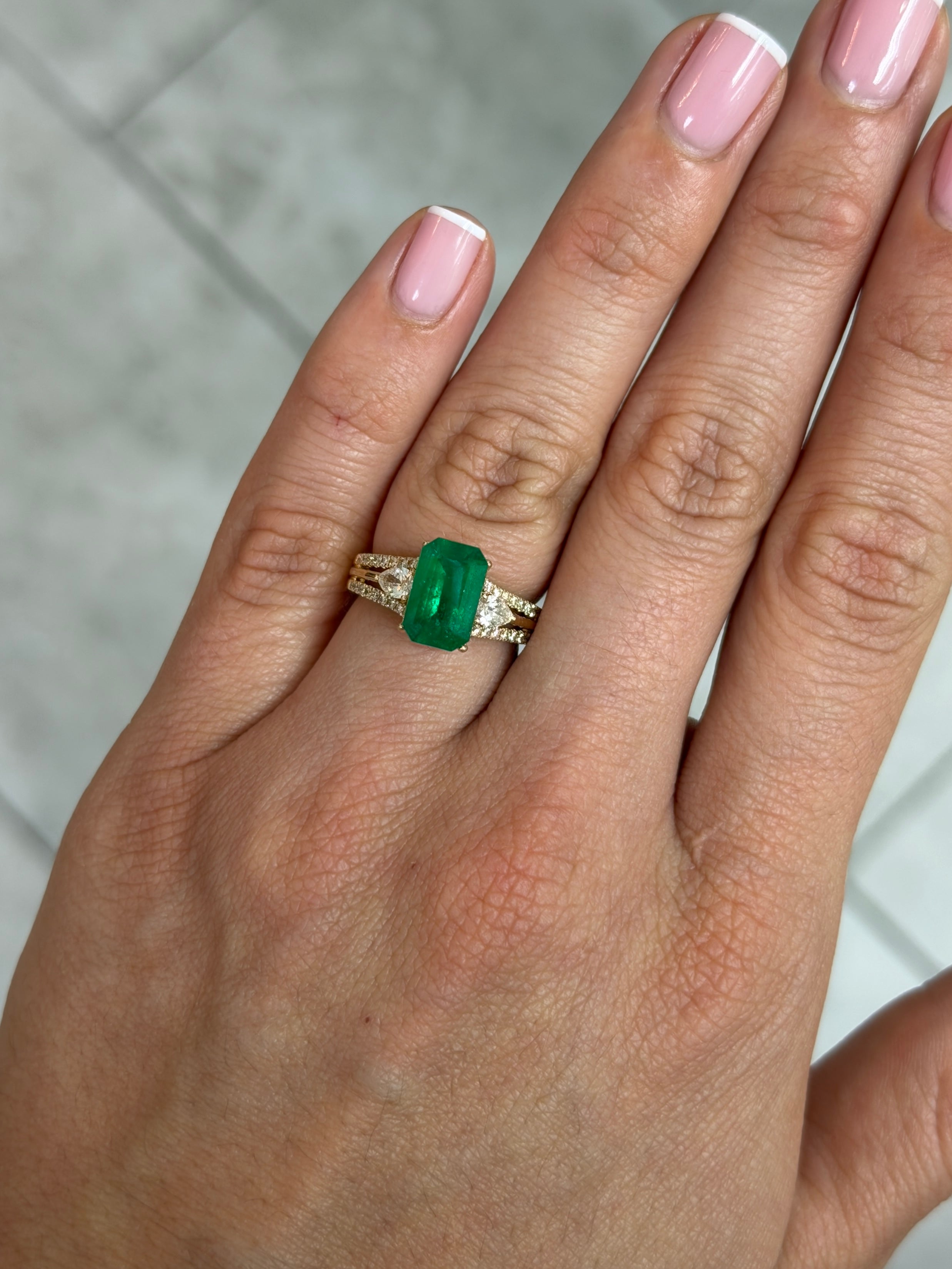 Deep jungle green 2.40 carat natural Colombian emerald in elongated emerald cut, showing its vibrant color and clarity.