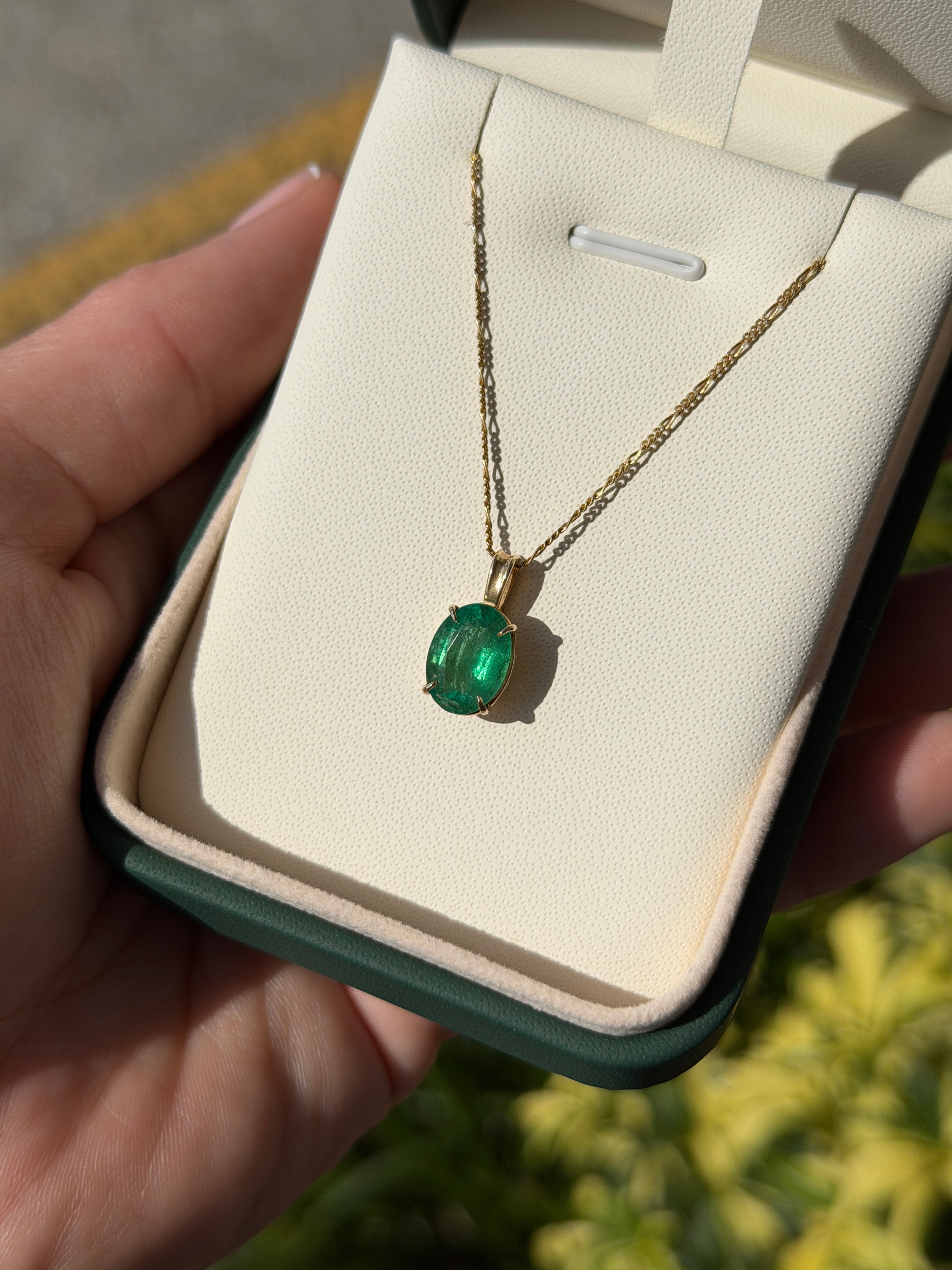 Oval 2.50 carat natural emerald solitaire pendant in 14K gold, featuring a vibrant green emerald on a delicate chain.