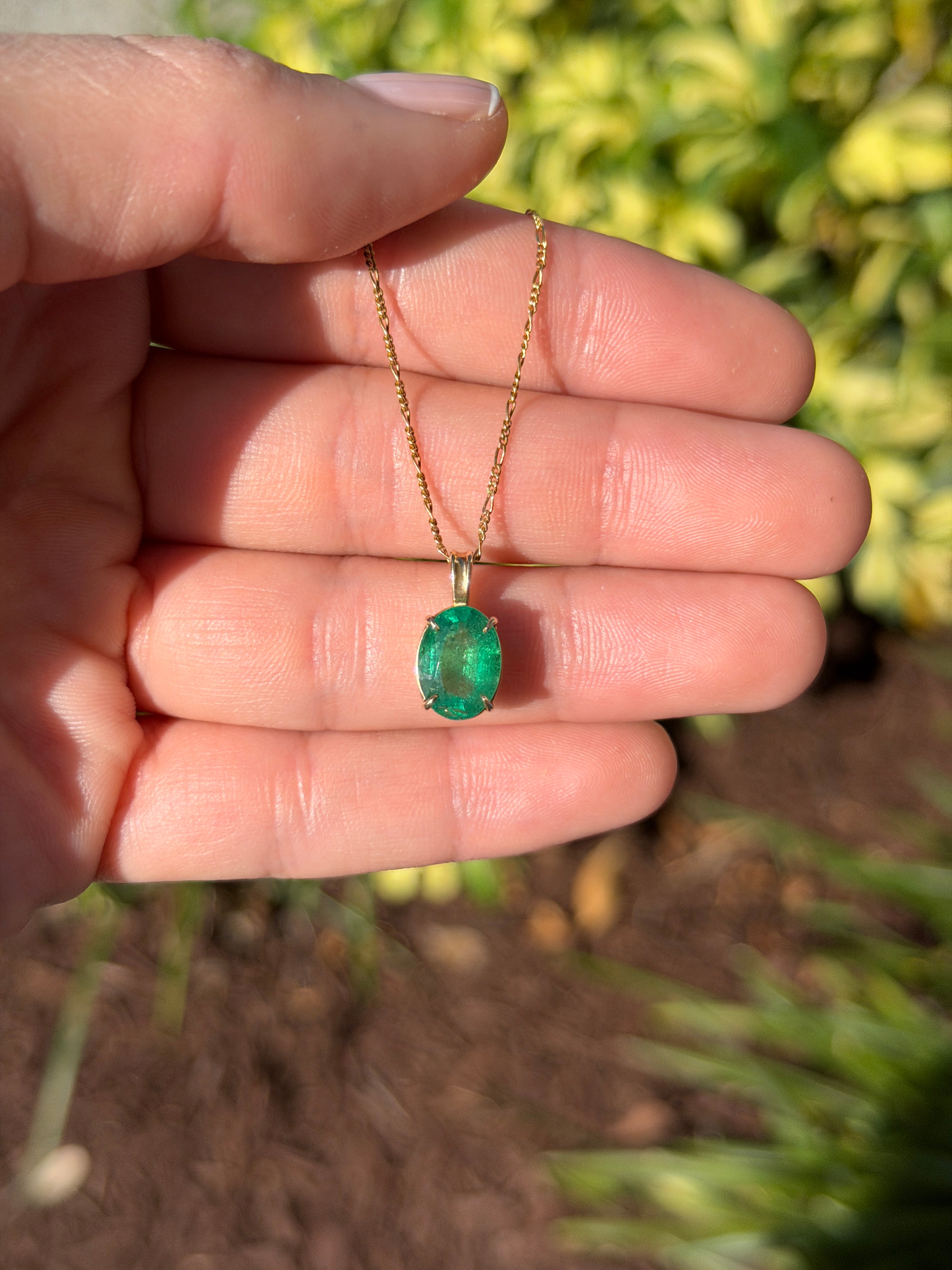 Oval 2.50 carat natural emerald solitaire pendant in 14K gold from JR Colombian Emeralds, showcasing a vibrant green gemstone.