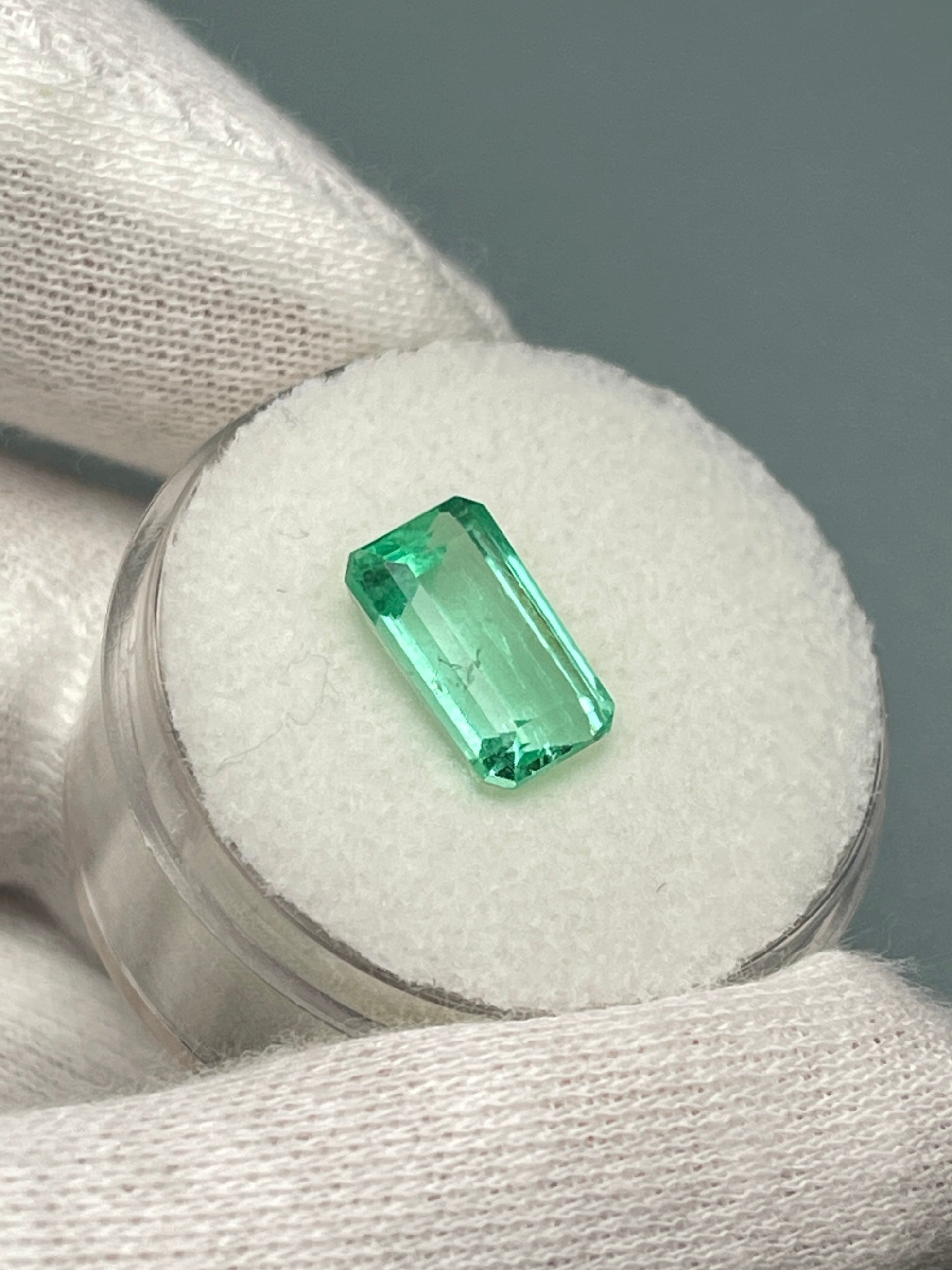 2.64 carat pastel yellowish-green Colombian emerald in an emerald cut, showcasing its vibrant color and clarity.