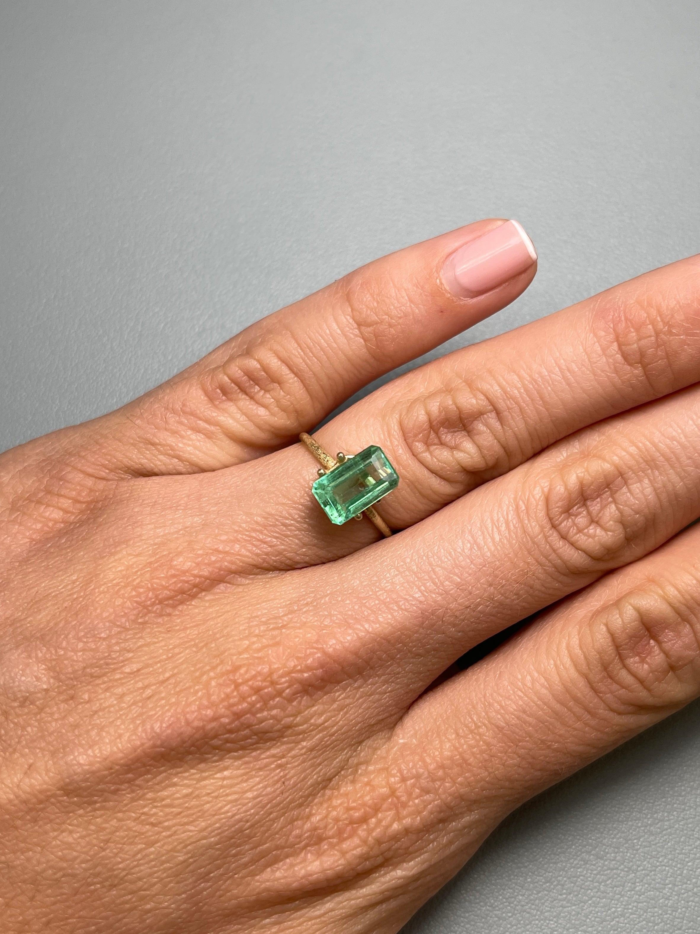 2.64 carat emerald cut Colombian emerald with pastel yellow-green hue, loose gemstone from JR Colombian Emeralds.
