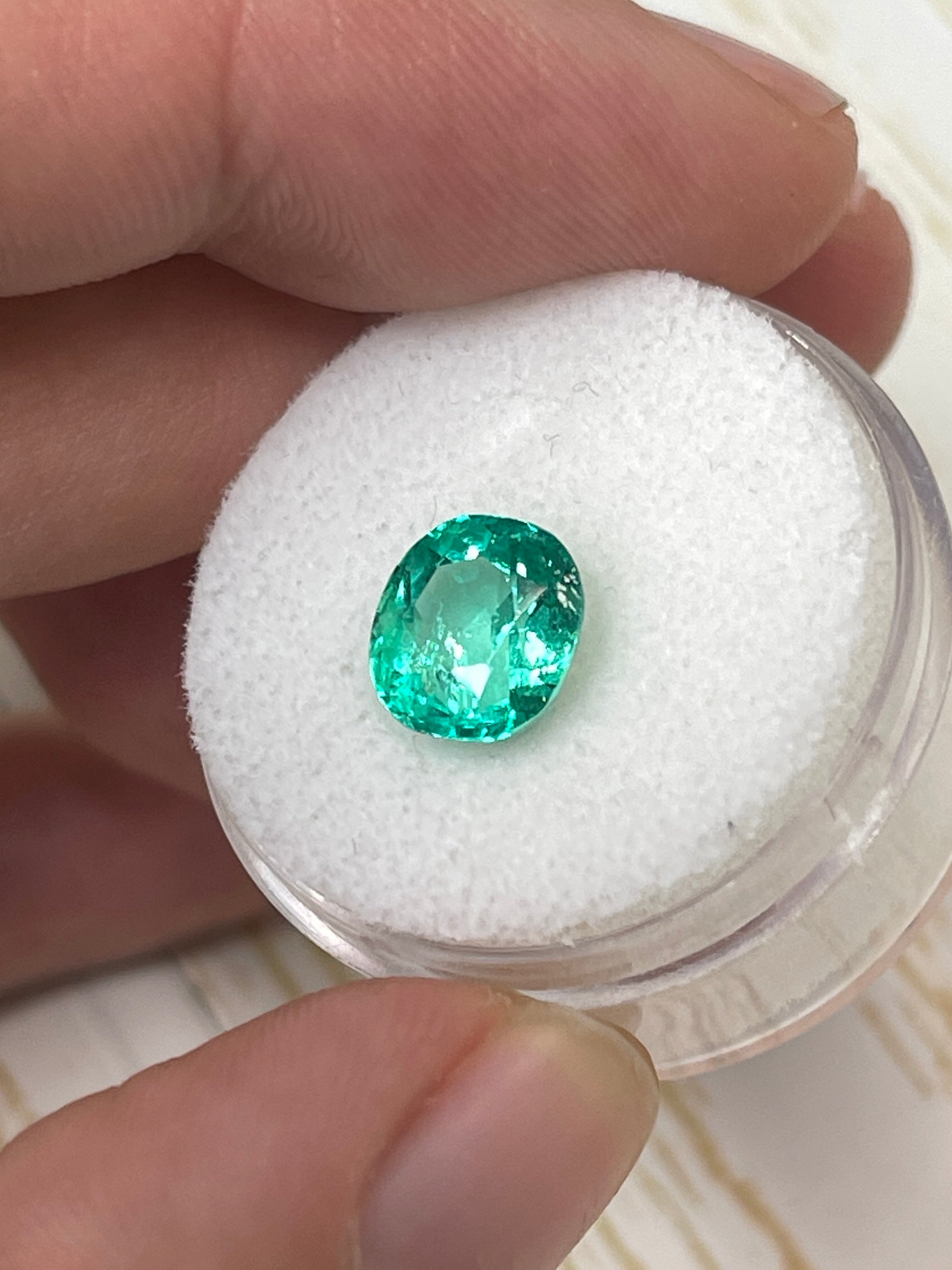 2.67 carat glowing Muzo green Colombian emerald loose cushion cut gemstone from JR Colombian Emeralds on a white background.