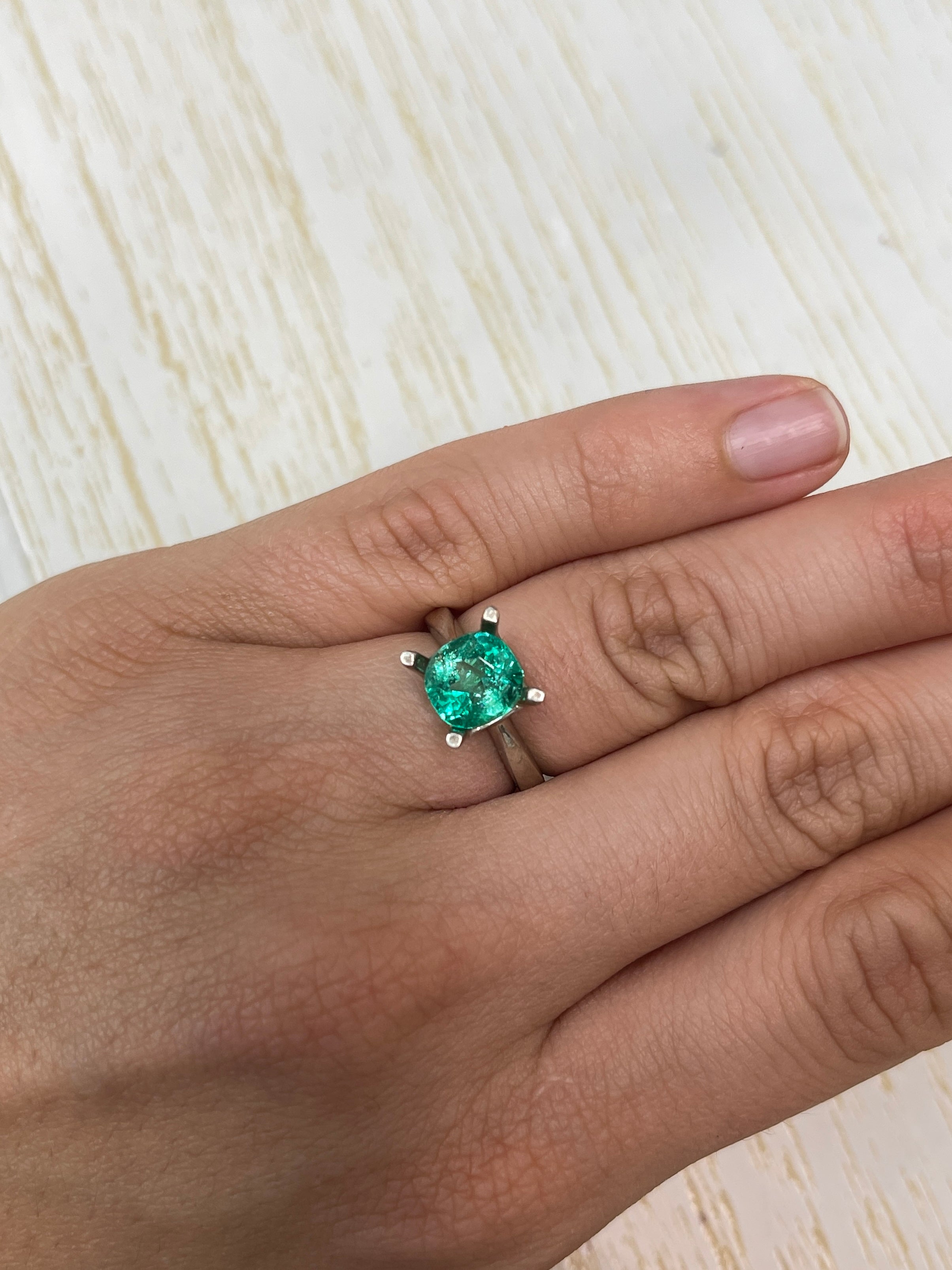 2.67 carat glowing Muzo green Colombian emerald loose cushion cut gemstone with natural brilliance and vibrant color.